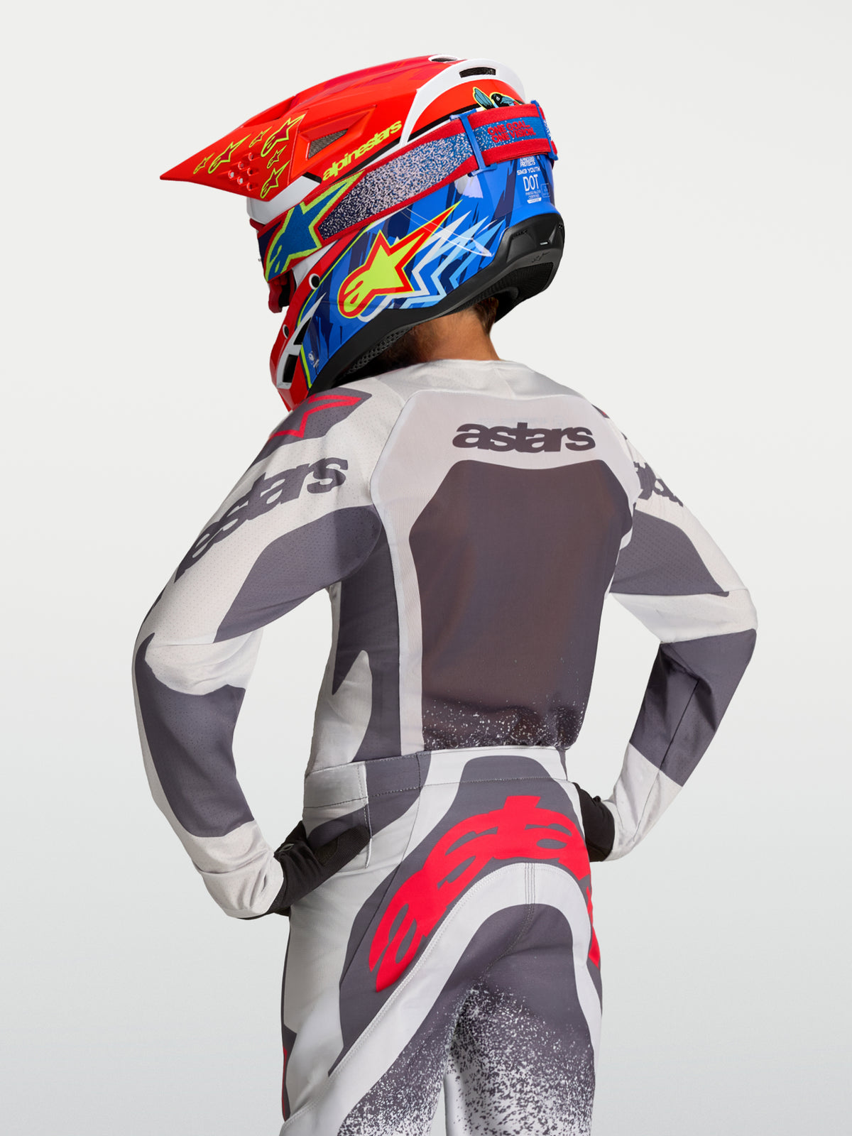Alpinestars camisola Supertech Swan juventude, motocross, cinzenta e lilás, malha respirável, vista traseira no piloto.
