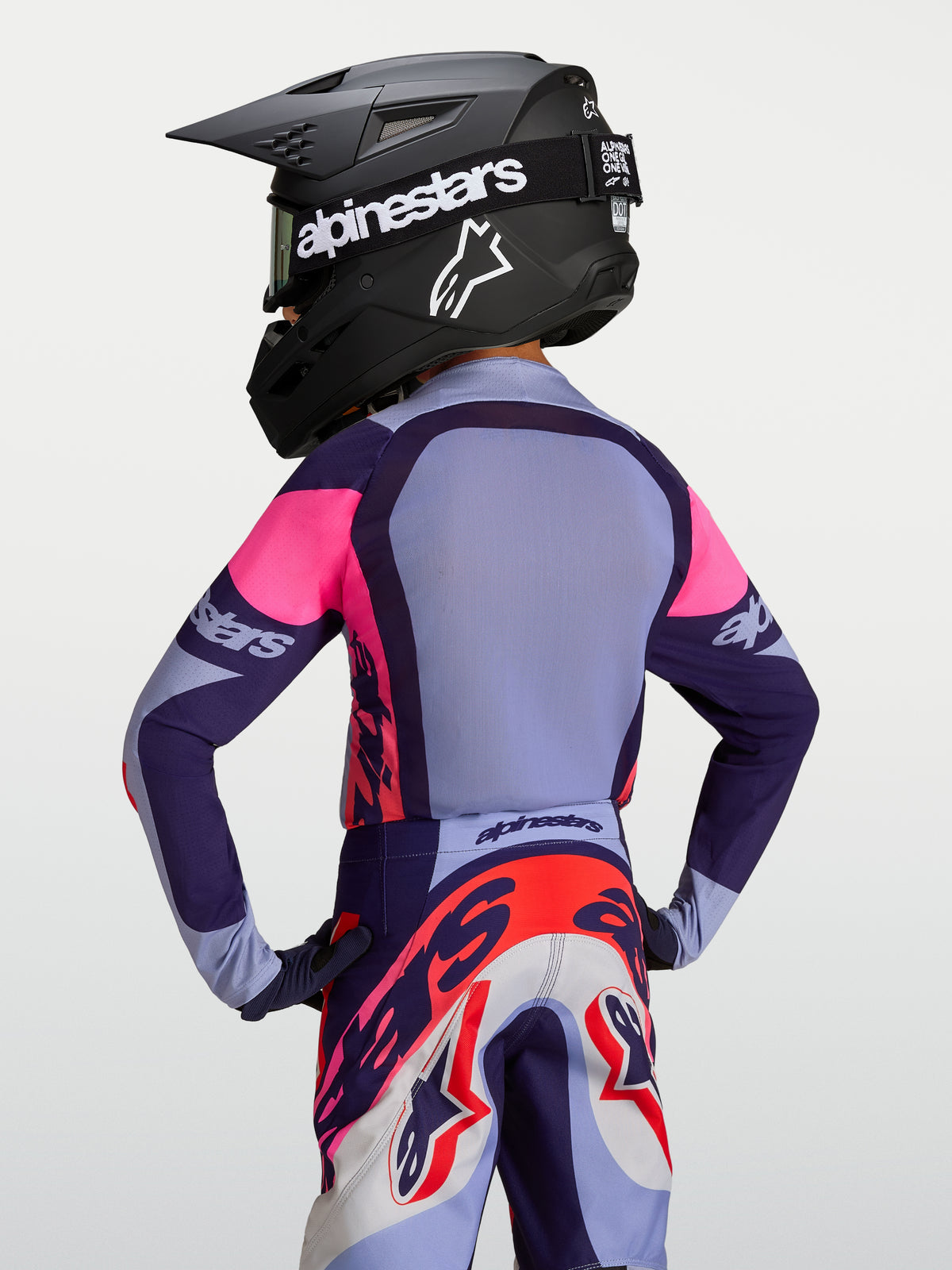 Camisola Alpinestars Supertech Dyna Jovem 2027, roxa e rosa, em malha de motocross, vista traseira no modelo.