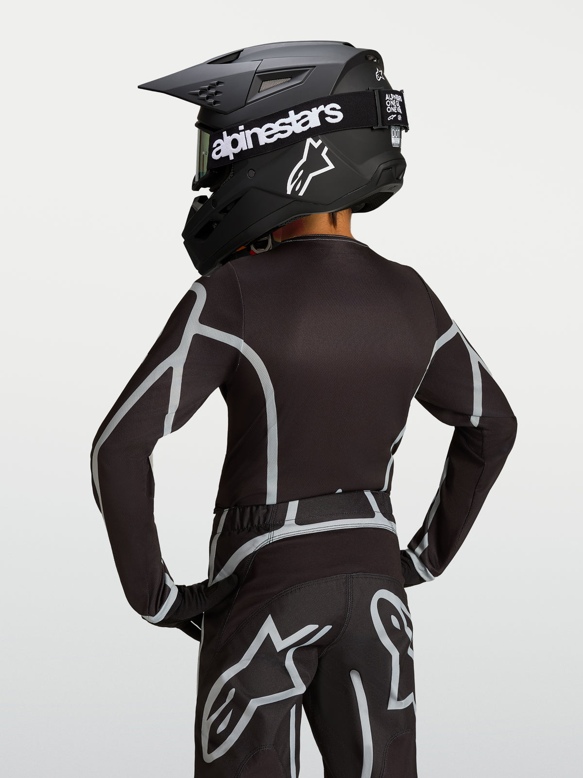 Alpinestars camisola Fluid Apex V2 Jovem, preta e prateada, vista traseira de equipamento de motocross com corte atlético.
