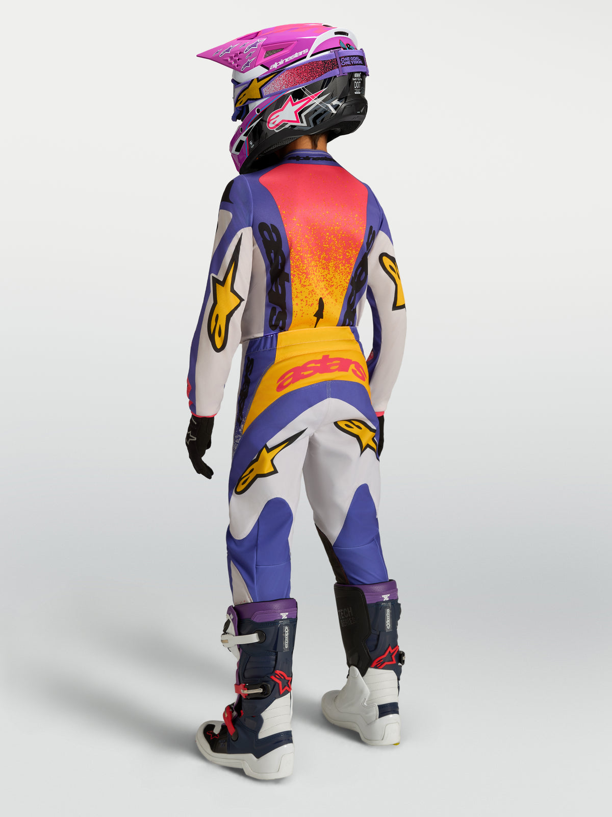 Alpinestars Camisola Fluid Drag Juventude 2027 e Conjunto de Equipamento, motocross azul e dourado, vista traseira estendida.