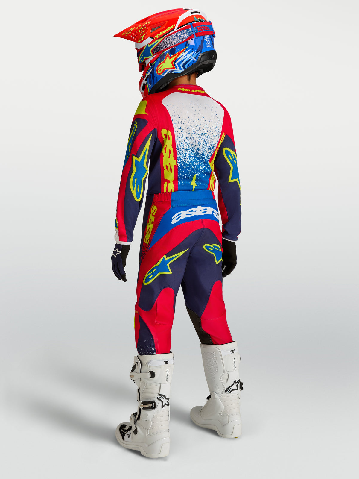 Alpinestars 2027 Youth Fluid Drag Gear Set, Blue Navy and Fire Red youth motocross outfit, rear view with white boots.