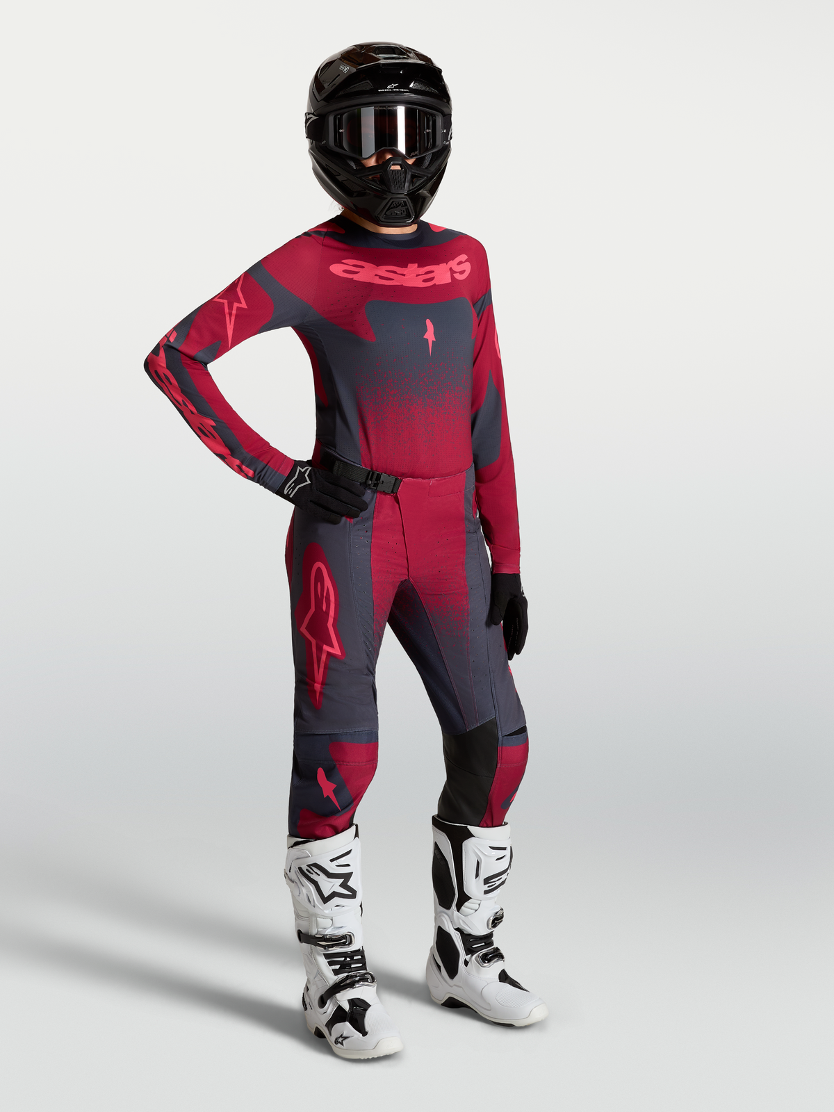 Alpinestars Stella Techstar Swan, camisola e calças de motocross para mulher, vermelho e cinzento escuro com botas brancas.