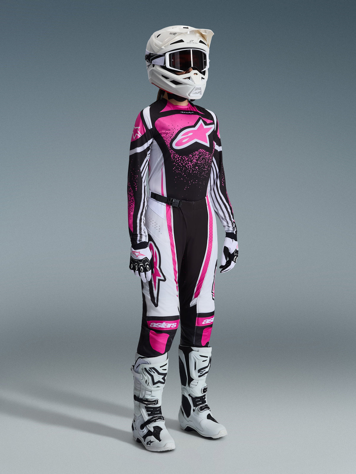 Alpinestars 2026 Stella Techstar Nomur Gear Set, equipamento completo de motocross para mulher, camisola vibrante em cor-de-rosa, preto e branco com calças a condizer, capacete e óculos brancos, botas brancas e pretas, conjunto de motocross profissional coordenado