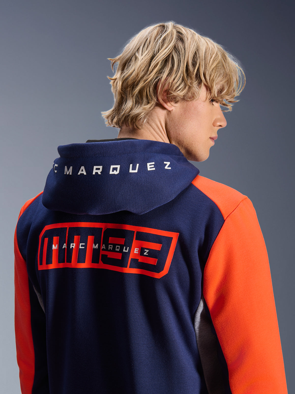 Alpinestars MM93 Chrome V2 Sport Hoodie, azul marinho com mangas laranja vibrantes, logótipo MM93 grande em vermelho e branding Marc Marquez nas costas, letras brancas no capuz, hoodie casual de motociclismo urbano