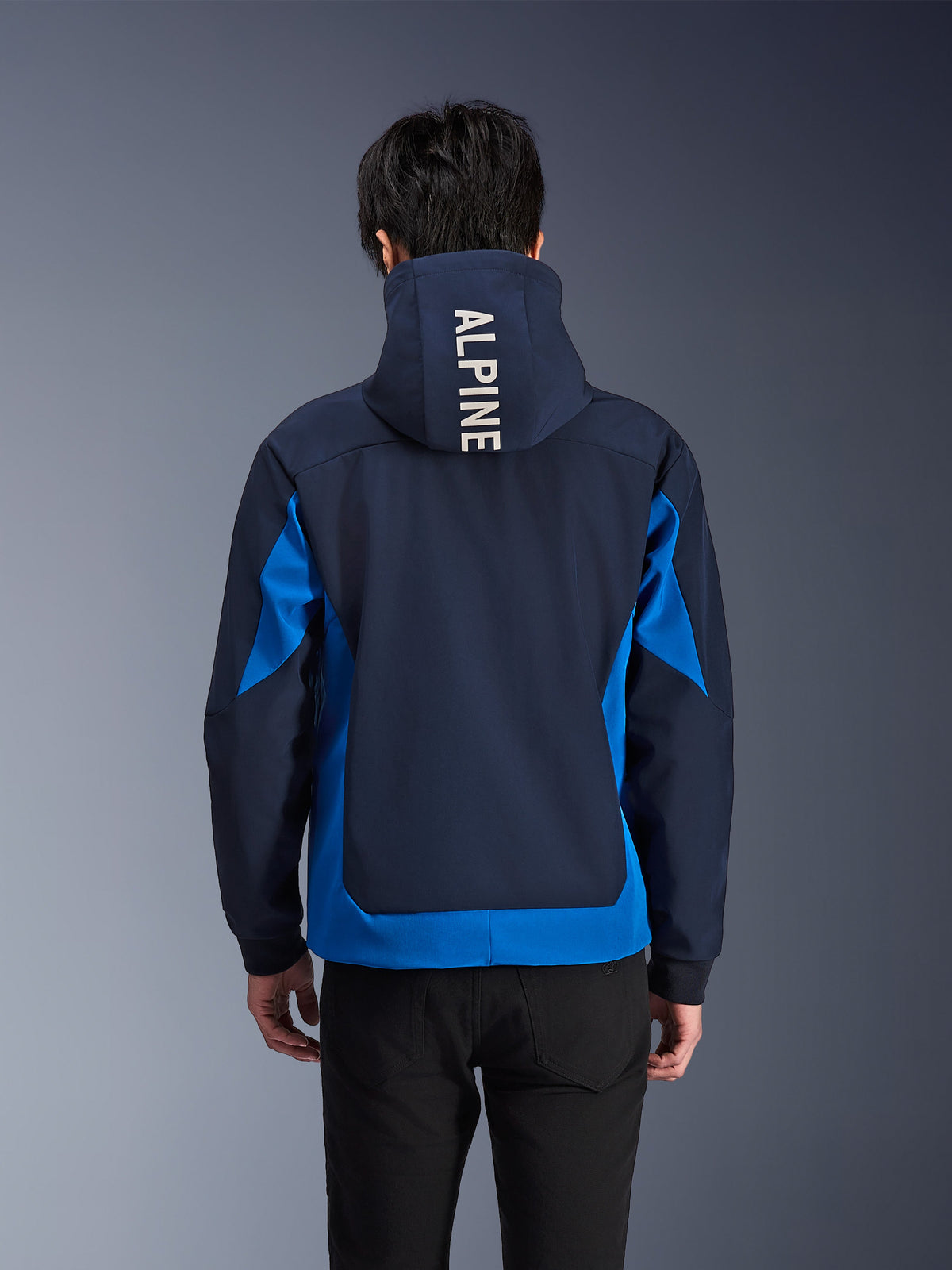 Alpinestars Radium Tech Hoodie, Night Navy and Royal Blue motorcycle jacket, back view showing white 'ALPINE' branding on the hood, urban performance gear with athletic fit and contrasting color panels