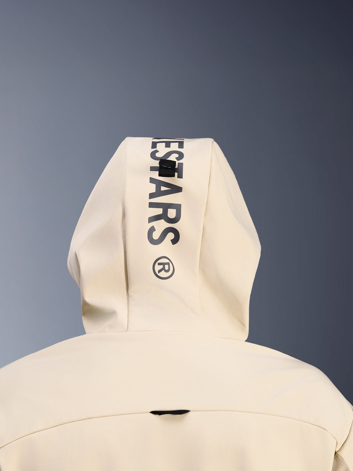 Hoodie Alpinestars Radium Tech em Mastic Aluminum, vista traseira em grande plano do capuz mostrando a marca Alpinestars vertical a preto e o sistema de presilha de fixação do capuz, pormenor de vestuário urbano para motociclo