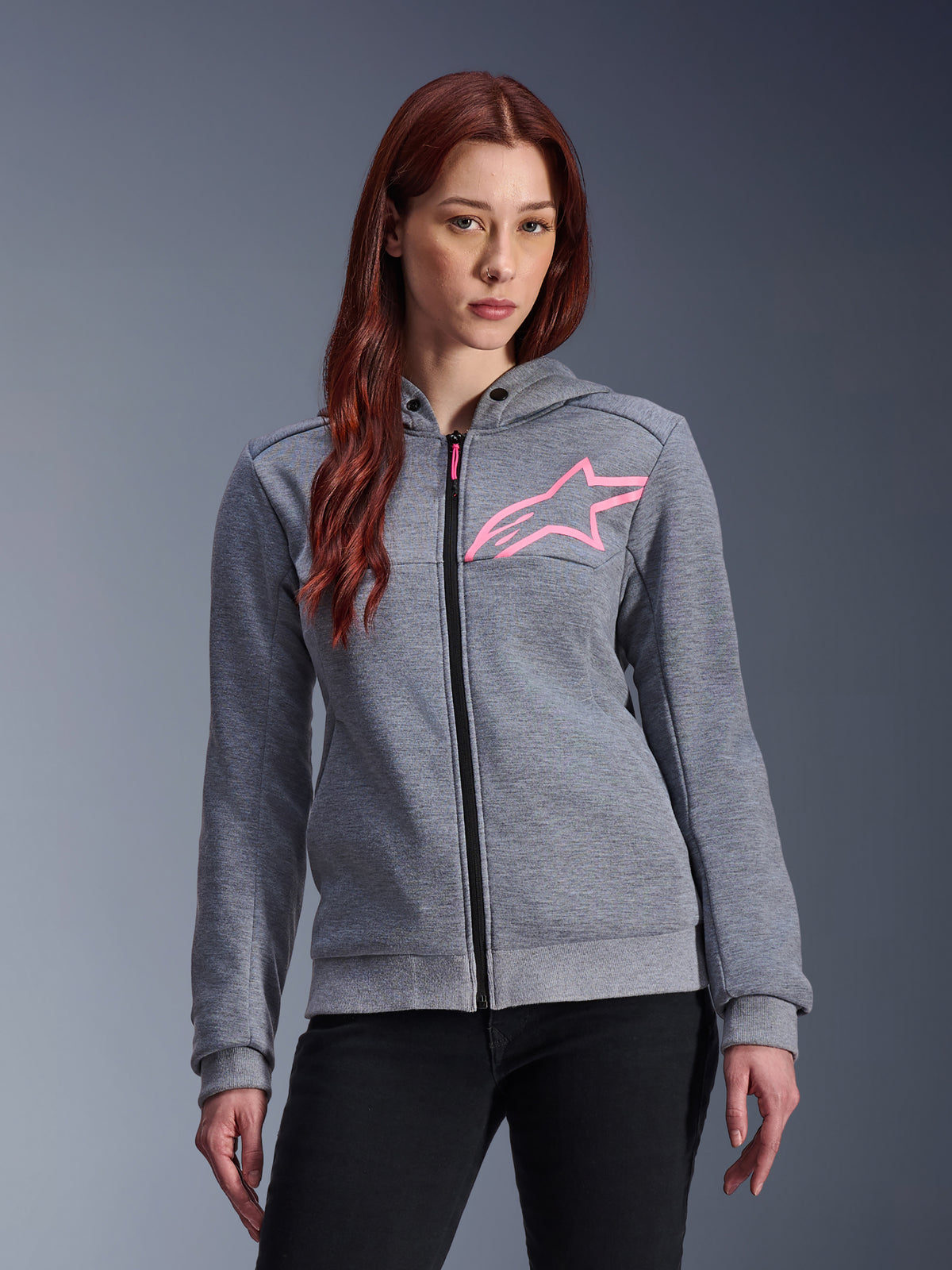 Alpinestars Stella Chrome V2 Sport Hoodie, hoodie de motociclismo para mulher, cinzento mesclado com logótipo de estrela em rosa fluo, tecido polar técnico com punhos e bainha canelados, fecho de correr frontal preto com puxador rosa, vestuário casual urbano para condução usado com calças pretas