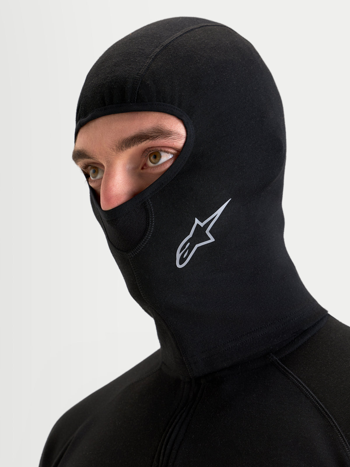 Alpinestars At 8 Merino Balaclava, balaclava térmica de moto para homem, preta, num modelo a mostrar construção em mistura de merino, costuras planas e logótipo Astar estampado
