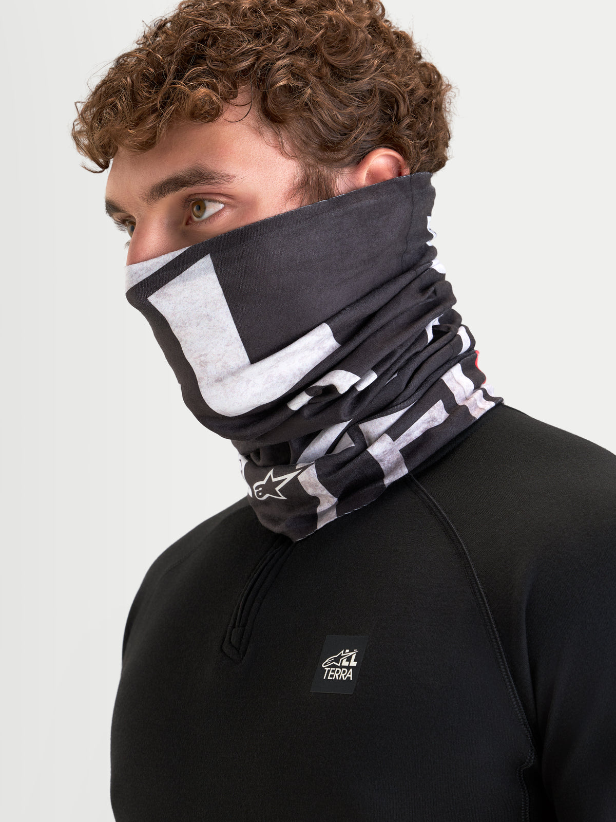 Alpinestars Buff All Terra Primaloft, gola térmica de moto para o tempo frio, preta e cinzenta, usada por um modelo a mostrar cobertura do rosto e do pescoço com construção têxtil isolante