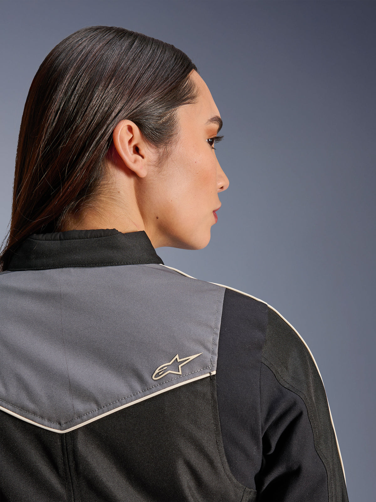 Alpinestars Stella T-Dyno WR Jacket, casaco de motociclismo feminino, preto, cinzento escuro e ecru, vista traseira aproximada do ombro e da pala com painel cinzento e logótipo de estrela ecru, equipamento de condução de inspiração vintage