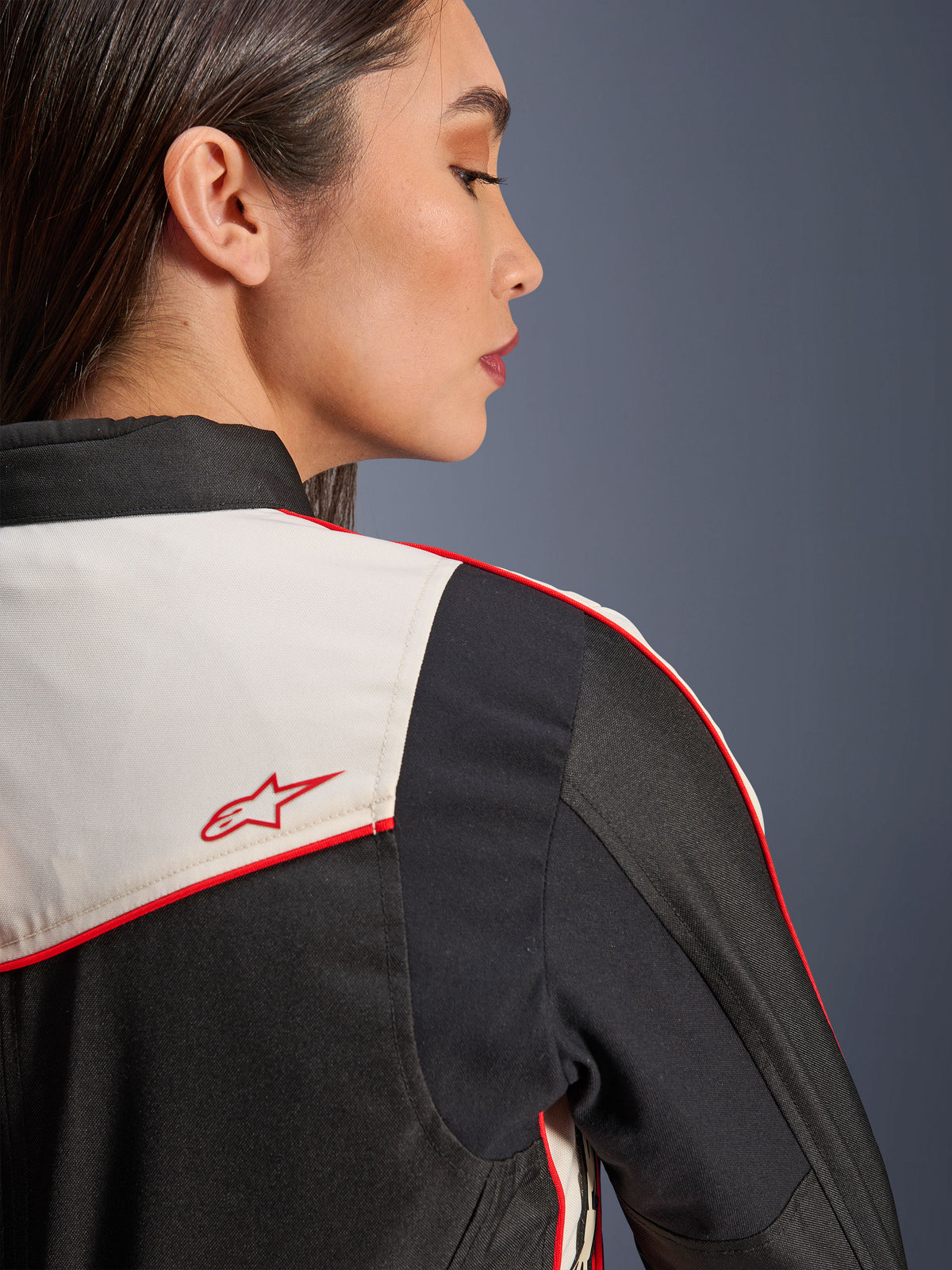 Casaco Alpinestars Stella T-Dyno WR em Black Ecru Bright Red, pormenor do ombro e das costas com painéis ecru, vivos vermelhos e logótipo de estrela Alpinestars em vermelho, equipamento têxtil de motociclismo para mulher