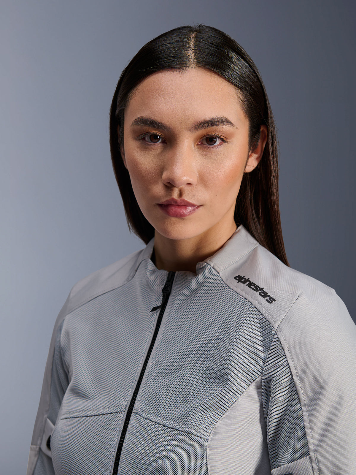 Casaco Alpinestars Stella C-1 Air, casaco de motociclismo para mulher prateado, retrato em grande plano com painéis de ventilação em malha técnica e logótipo preto no ombro, equipamento de condução urbano contemporâneo