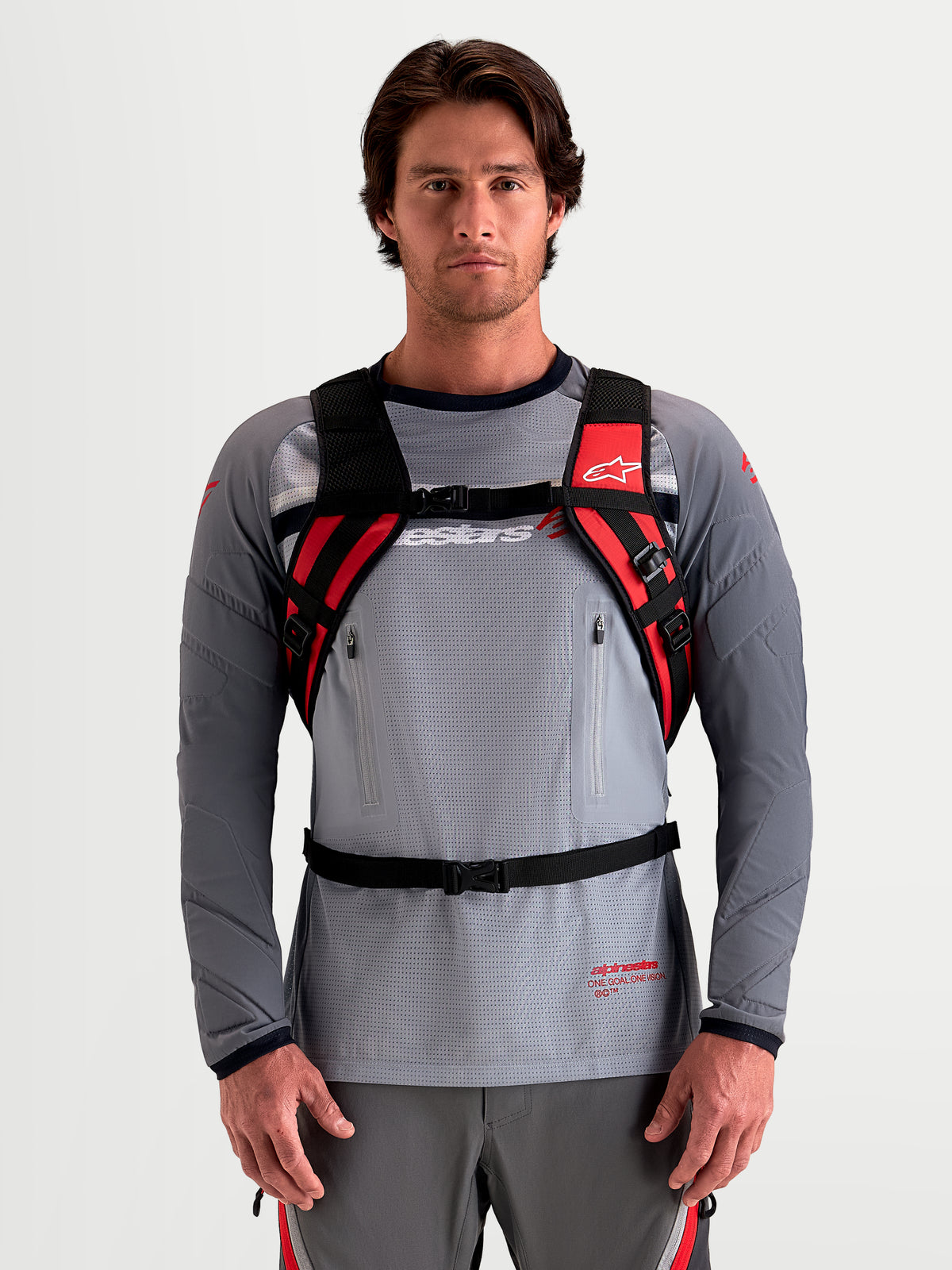 Alpinestars Mochila AT-9, mochila de motocross para homem, preta e vermelho vivo com alças de ombro acolchoadas e sistema de arnês, vista frontal num modelo