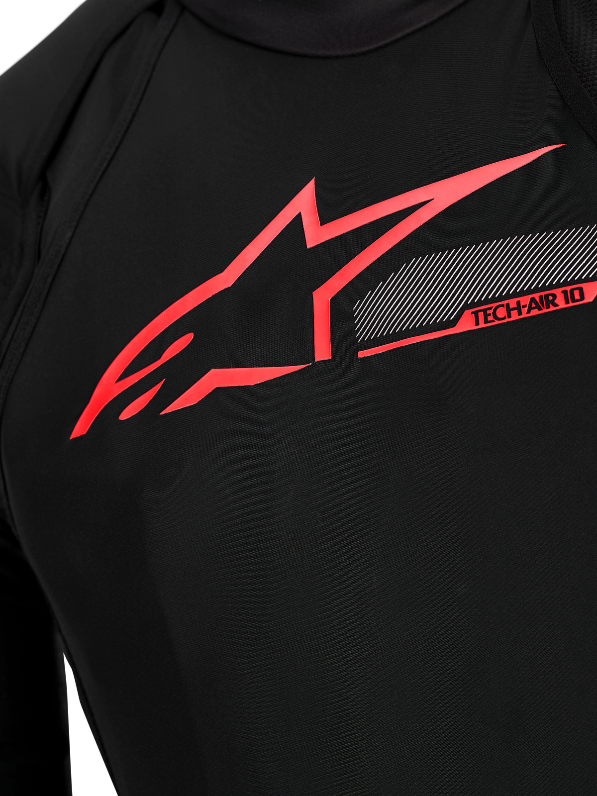Detalhe do peito do Airbag Tech-Air 10 V2 Race, em tecido técnico preto com logótipo Alpinestars e gráficos vermelhos.