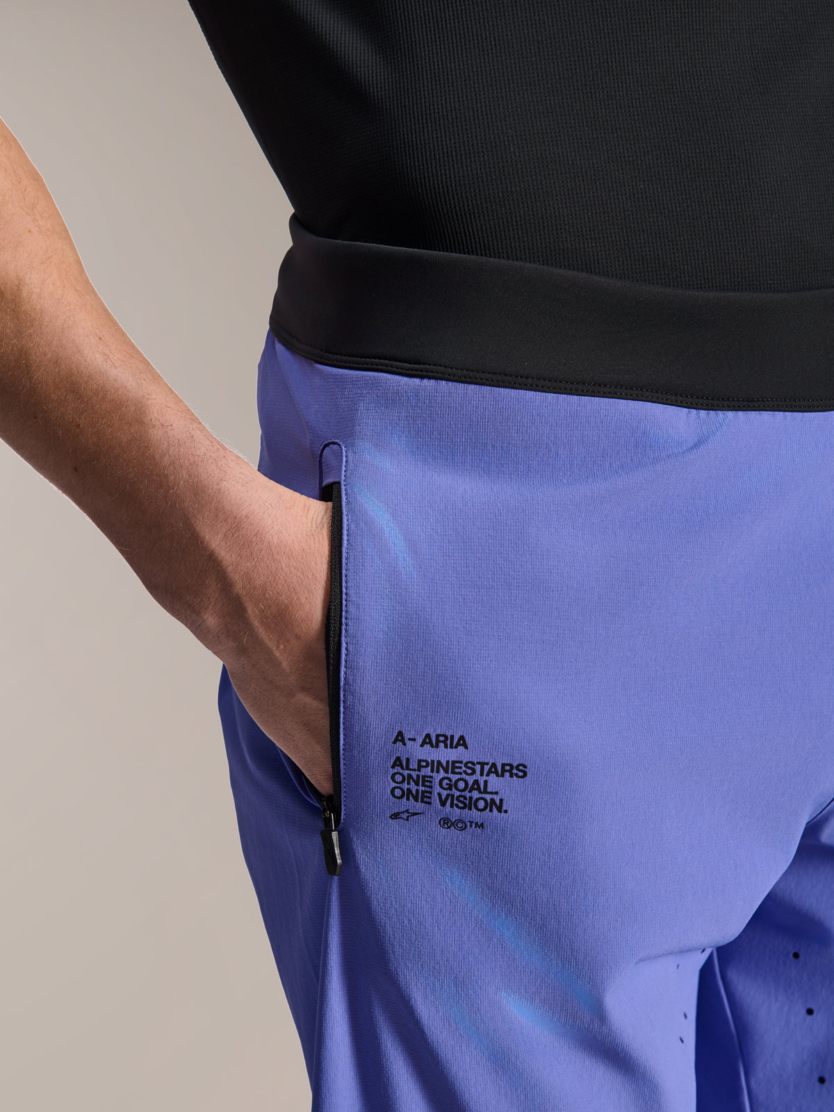 Alpinestars A-Aria Lite Short, calções de MTB, Baja Blue, grande plano que mostra o bolso frontal com fecho de correr e o logótipo lateral com o texto "One Goal. One Vision.", cintura preta e tecido técnico para mountain bike
