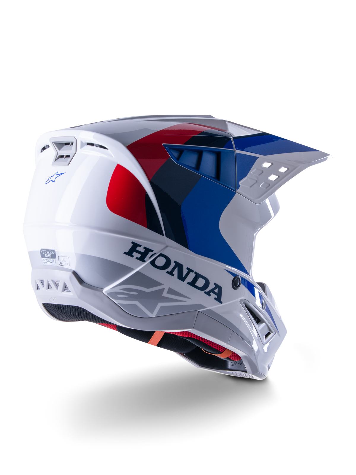 Alpinestars Honda S-M5 Helmet ECE, capacete de motocross, branco, azul e vermelho brilhante, com logótipos Honda e Alpinestars destacados, concha aerodinâmica com aberturas de ventilação integradas e viseira ajustável, equipamento de proteção para todo-o-terreno