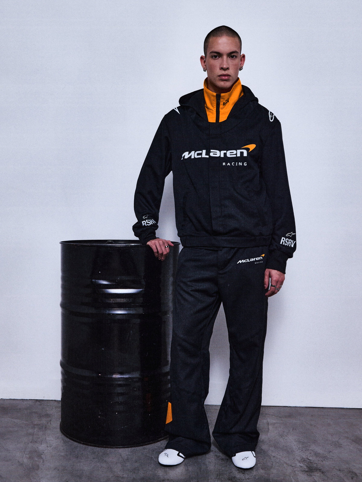 Alpinestars RSRV Arena Suit Jacket, casaco de corrida McLaren Racing, preto com forro laranja, logótipo branco, equipamento premium de motorsport