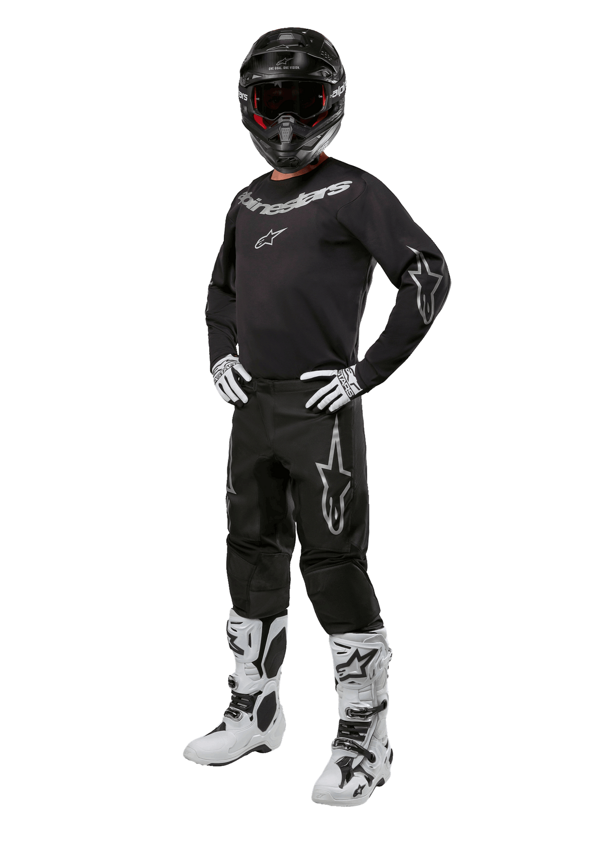 Conjunto de Equipamento Alpinestars 2024 Fluid Graphite, equipamento completo de corrida de motocross, preto com logótipos cinzentos e brancos, com camisola e calças usadas com capacete preto a condizer, luvas e botas brancas e pretas, concebido para proteção em todo-o-terreno