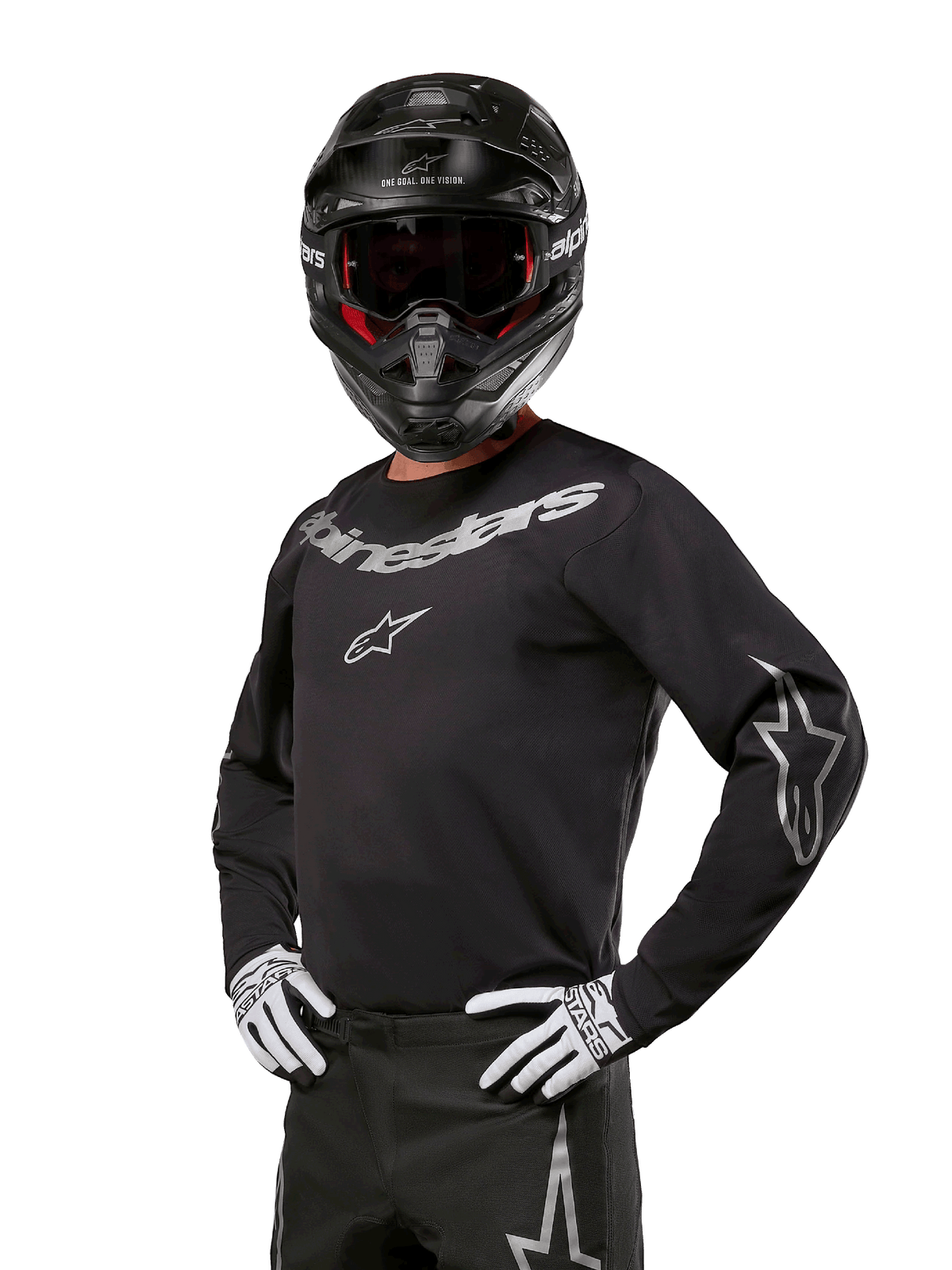 Alpinestars 2024 Fluid Graphite Jersey, camisola de motocross preta e prateada, corte de performance de manga comprida, usada com capacete preto e luvas brancas, com logótipo Alpinestars prateado, equipamento de corrida para todo-o-terreno