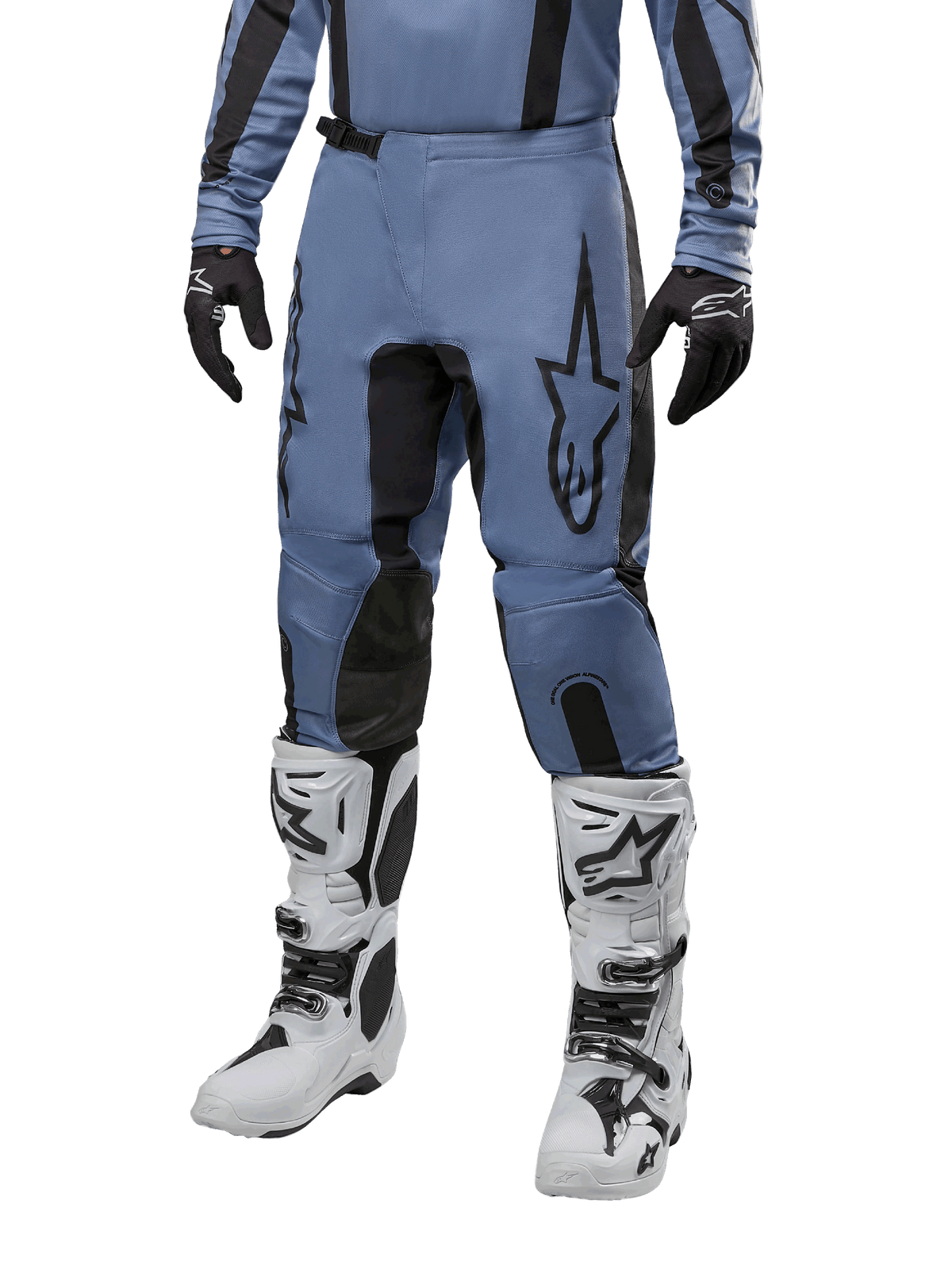 Alpinestars 2024 Fluid Lurv Pants, calças de motocross, azul-claro e preto, usadas com camisola de manga comprida a condizer e botas de motocross brancas, com um logótipo de estrela preto proeminente na coxa e painéis internos reforçados nos joelhos, vista frontal em fundo branco