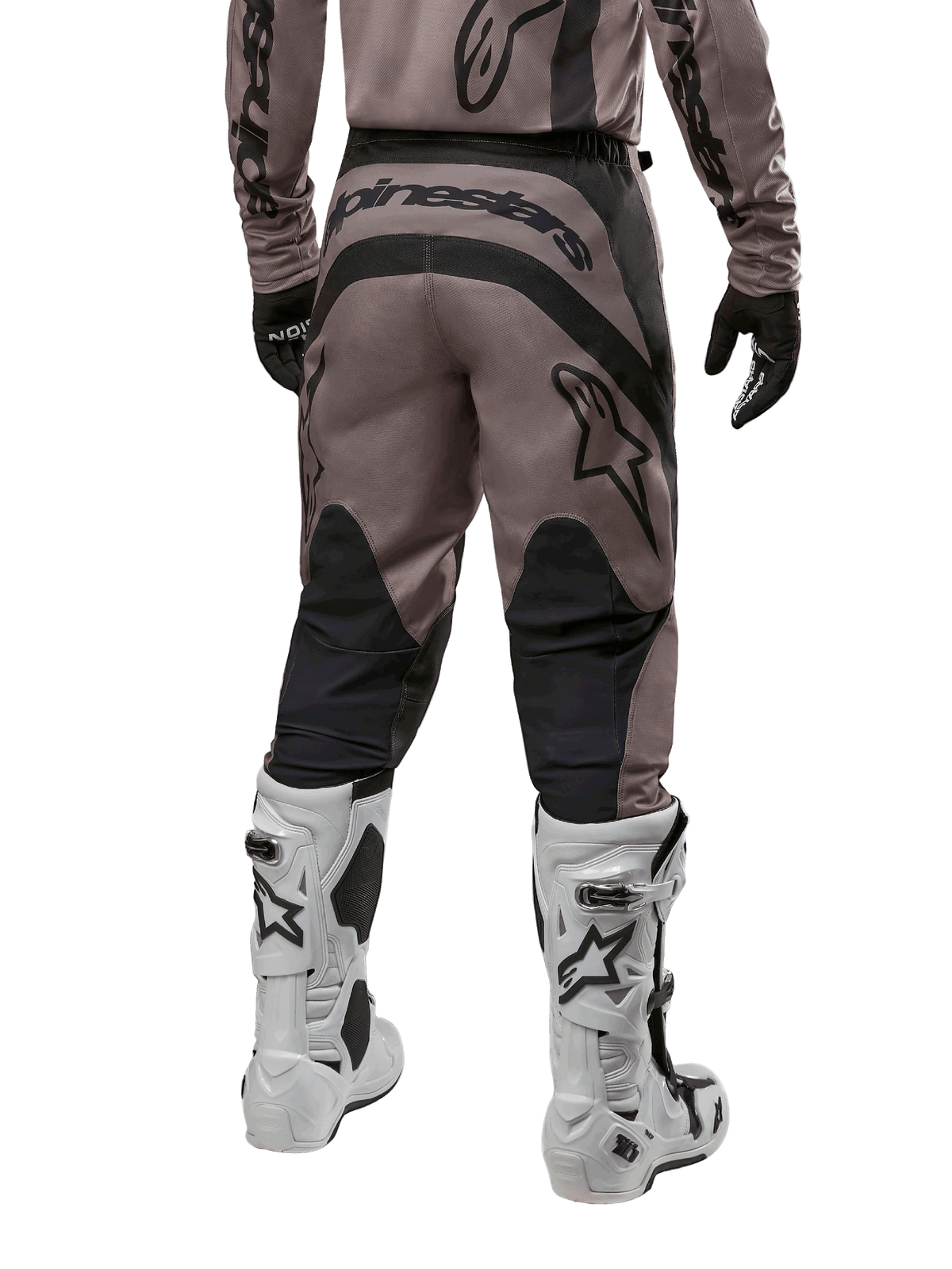 Alpinestars 2024 Fluid Lurv Pants, calças de motocross, Mud Black, vista traseira com grande logótipo Alpinestars preto no assento e painéis pretos nos gémeos, usadas com botas de motocross brancas e pretas e camisola a condizer