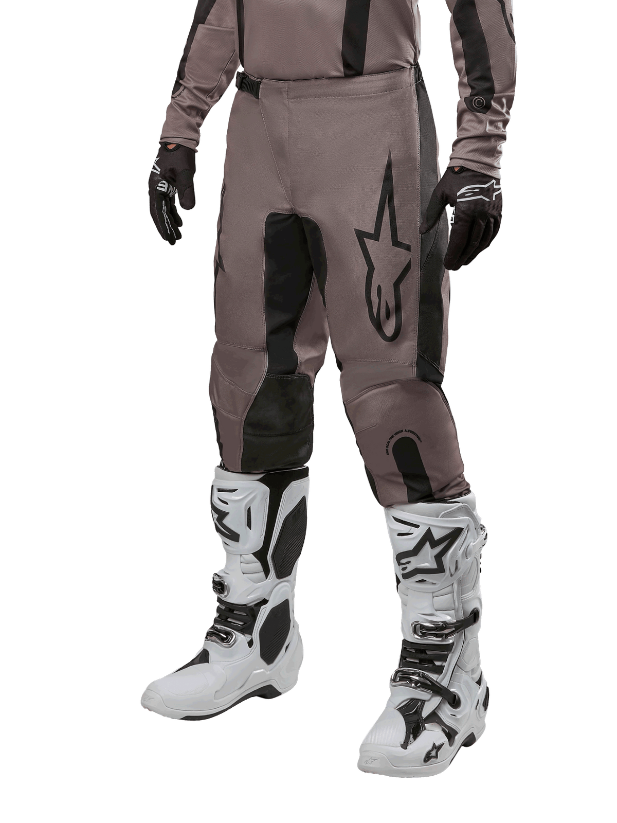 Alpinestars 2024 Fluid Lurv Pants, calças de motocross, Mud Black e pretas, com logótipo Alpinestars, usadas com luvas pretas e botas de motocross brancas, design desportivo para corridas todo-o-terreno
