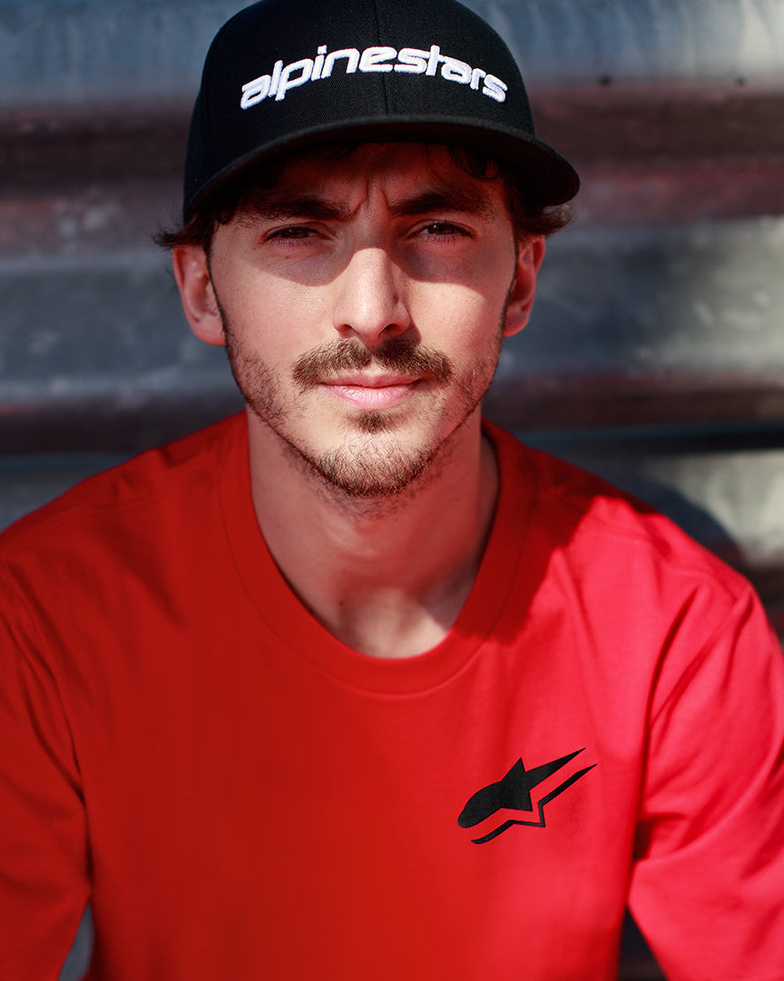 Alpinestars Formulate Csf Tee em vermelho, Francesco Bagnaia a usar t-shirt de manga curta com logótipo Astars preto e boné de basebol preto, streetwear casual de desportos motorizados