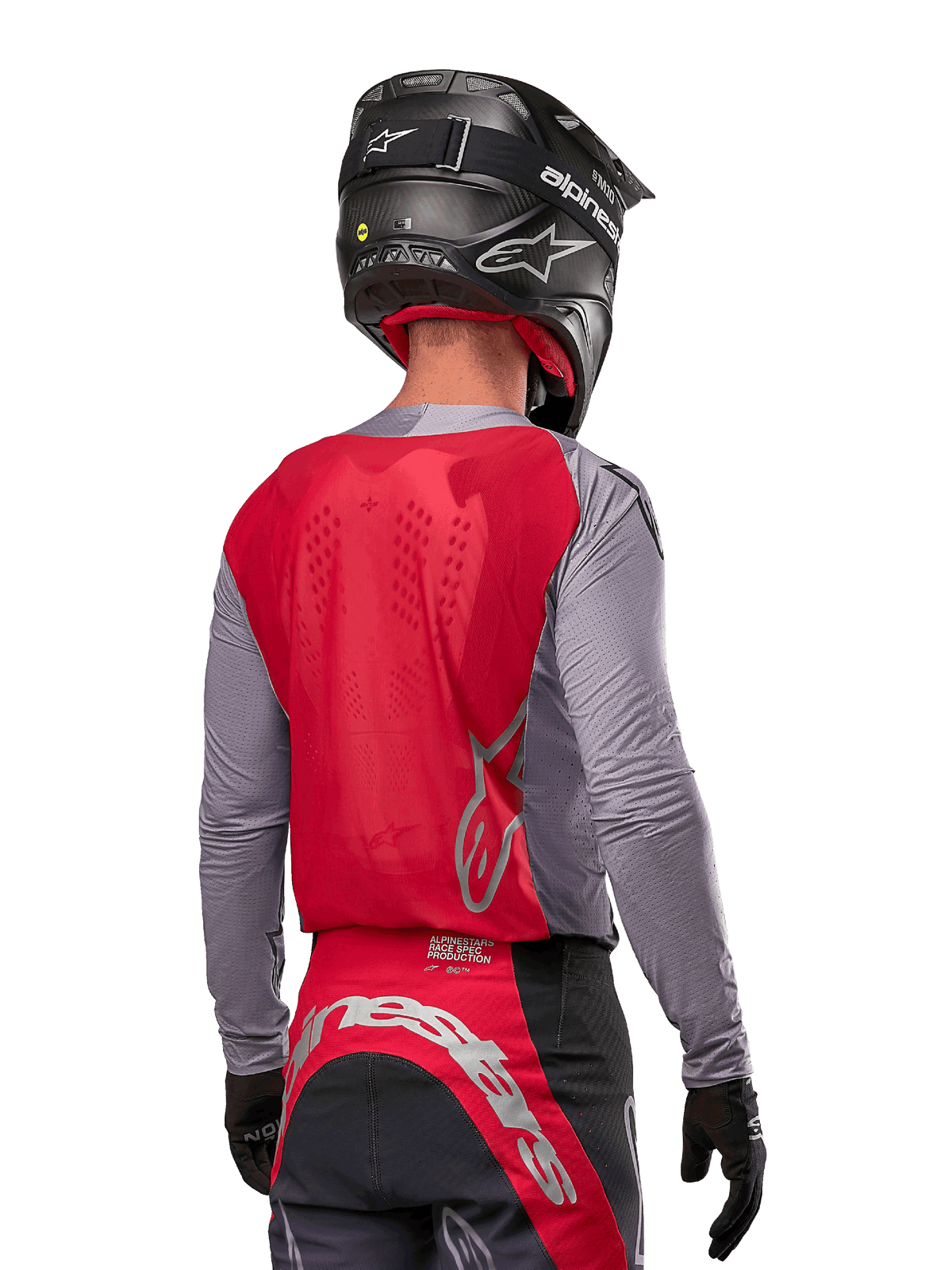 Piloto de motocross visto de costas a usar a camisola Alpinestars Supertech Dade 2024 em Iron Red Berry e cinzento, com painel traseiro em malha respirável, pormenores do logótipo em prateado, capacete preto e calças de corrida a condizer para desempenho profissional em todo-o-terreno