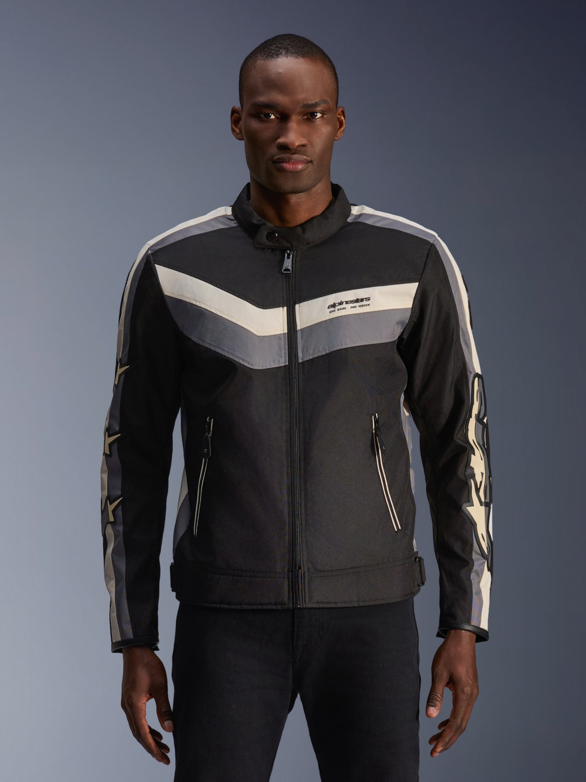 Alpinestars T-Dyno WR Jacket, casaco de motociclismo têxtil, preto, cinzento escuro e bege, com padrões de riscas chevron no peito e nos braços, corte de motociclista de inspiração vintage com gola alta, equipamento urbano contemporâneo para estrada