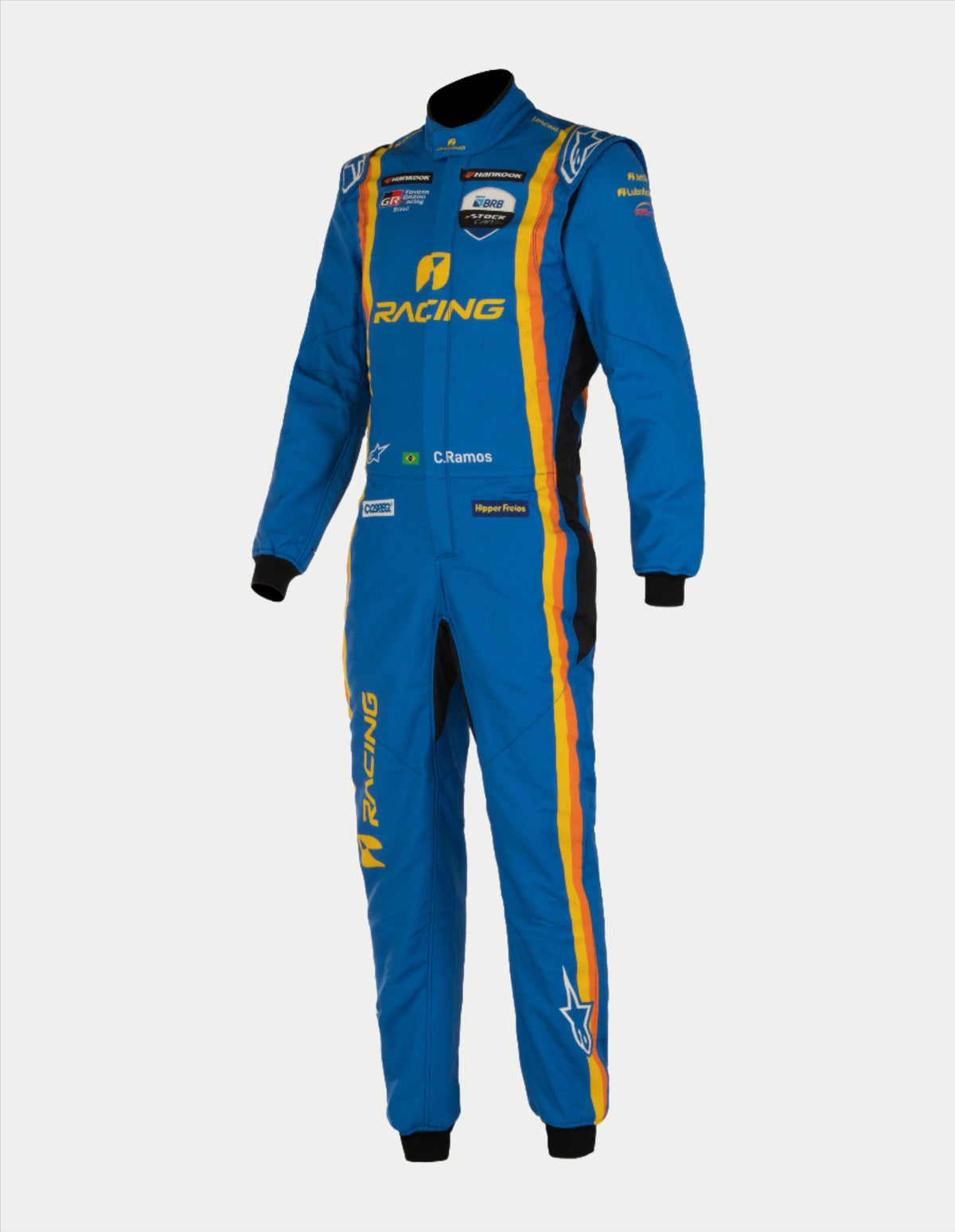 Alpinestars Tech Vision V3 Custom Suit, Professional Auto Racing Suit, Blue with yellow and orange stripes, featuring various sponsor logos and 'C. Ramos' personalization, lightweight Nomex construction with black cuffs