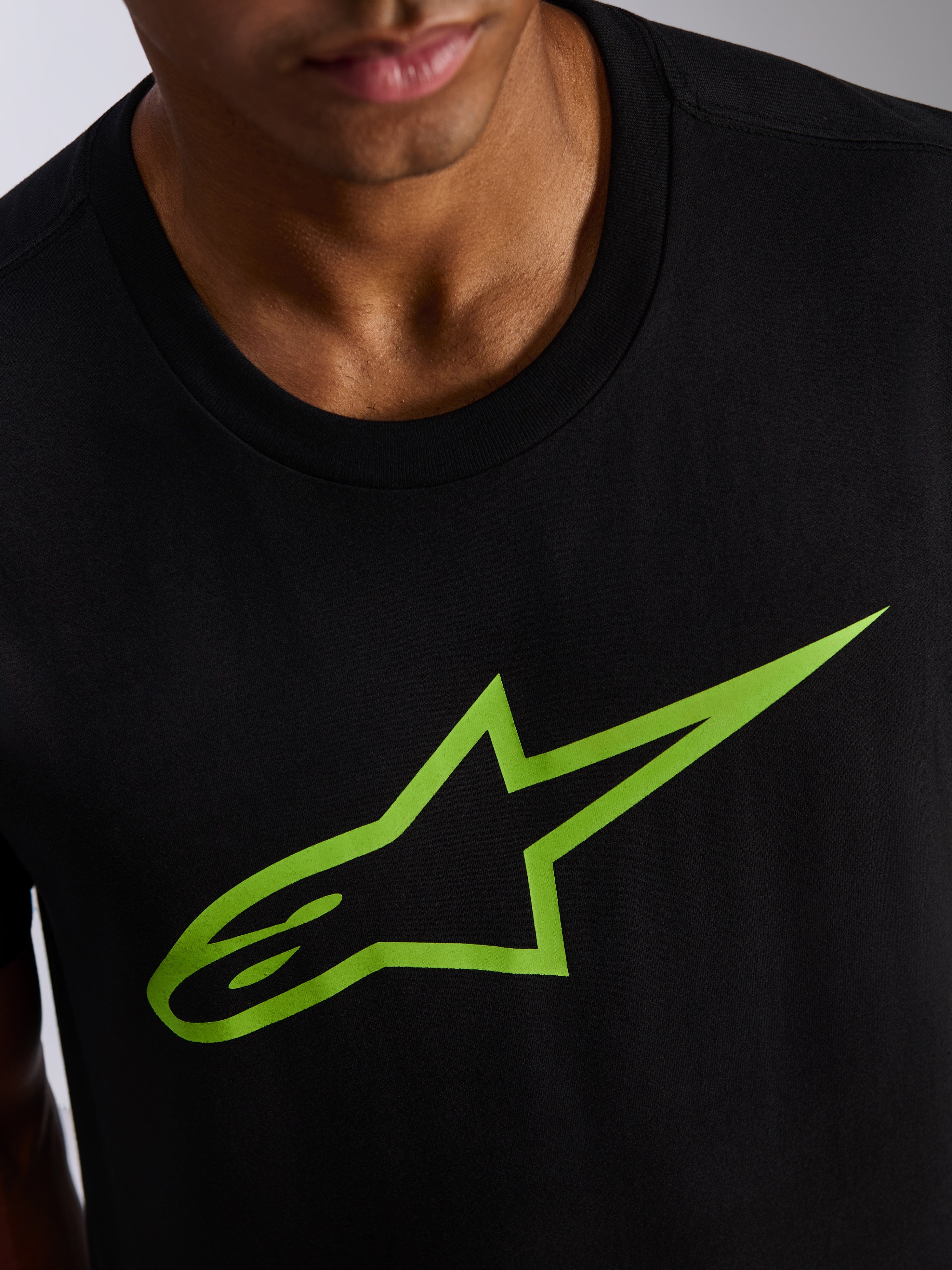 Alpinestars Ageless 2.0 CSF Tee, t-shirt de manga curta, preta com logótipo de estrela em verde vivo, grande plano do grafismo no peito e da gola, vestuário casual de estilo motorsport