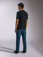 T-shirt Alpinestars Ageless Shadow CSF, t-shirt de manga curta, preta, vista traseira, usada com calças de ganga azuis e sapatilhas pretas, streetwear casual inspirado no desporto motorizado