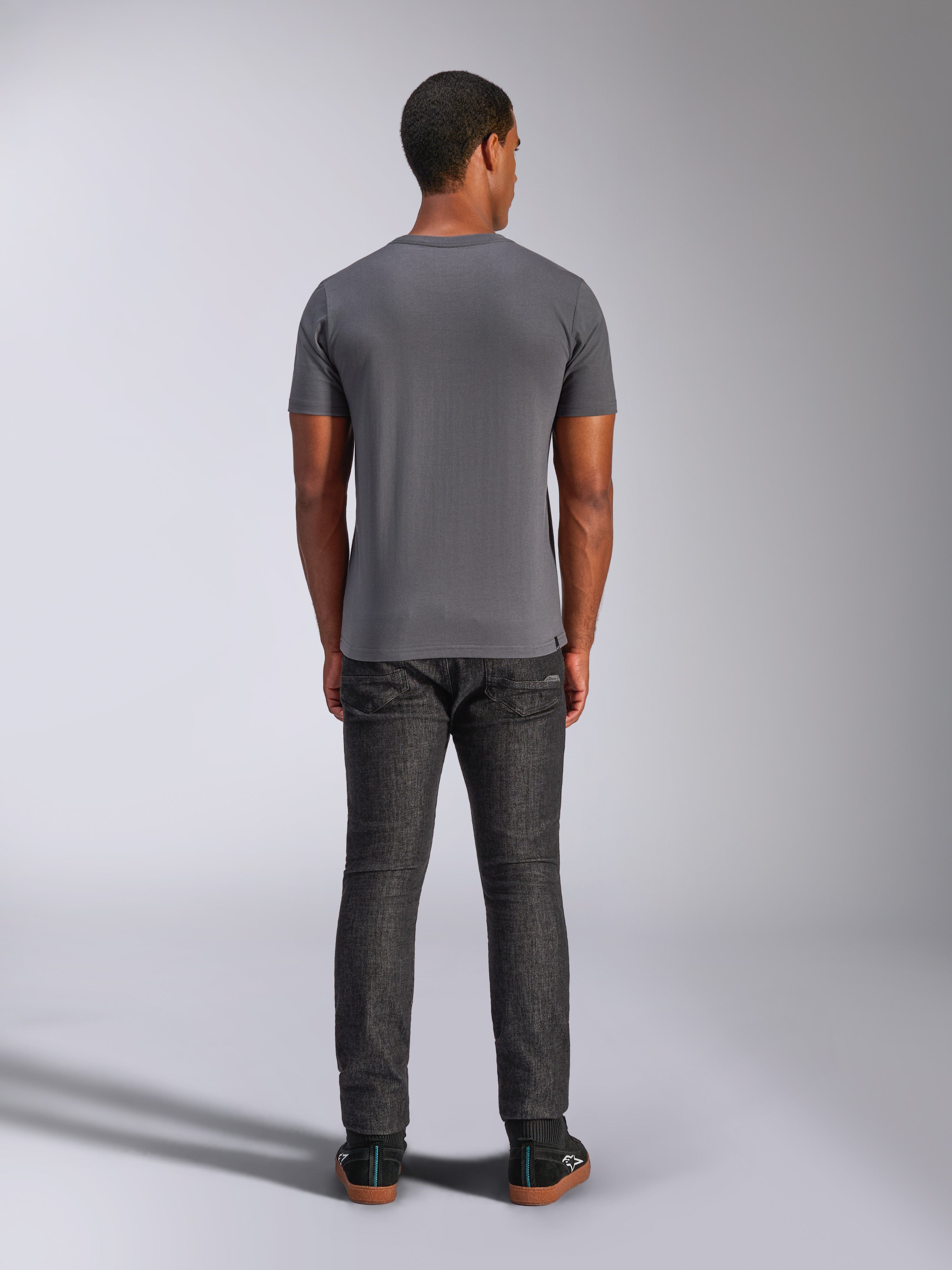 Alpinestars Always 2.0 CSF Tee, t-shirt de manga curta, cinzento carvão, vista traseira, usada com calças de ganga escuras, streetwear casual inspirado no desporto motorizado