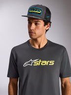 T-shirt Alpinestars Blaze 2.0 CSF, t-shirt de manga curta, cinzento carvão com logótipo branco e amarelo de alta visibilidade, usada com um boné de rede cinzento carvão a condizer, vestuário desportivo casual inspirado no desporto motorizado