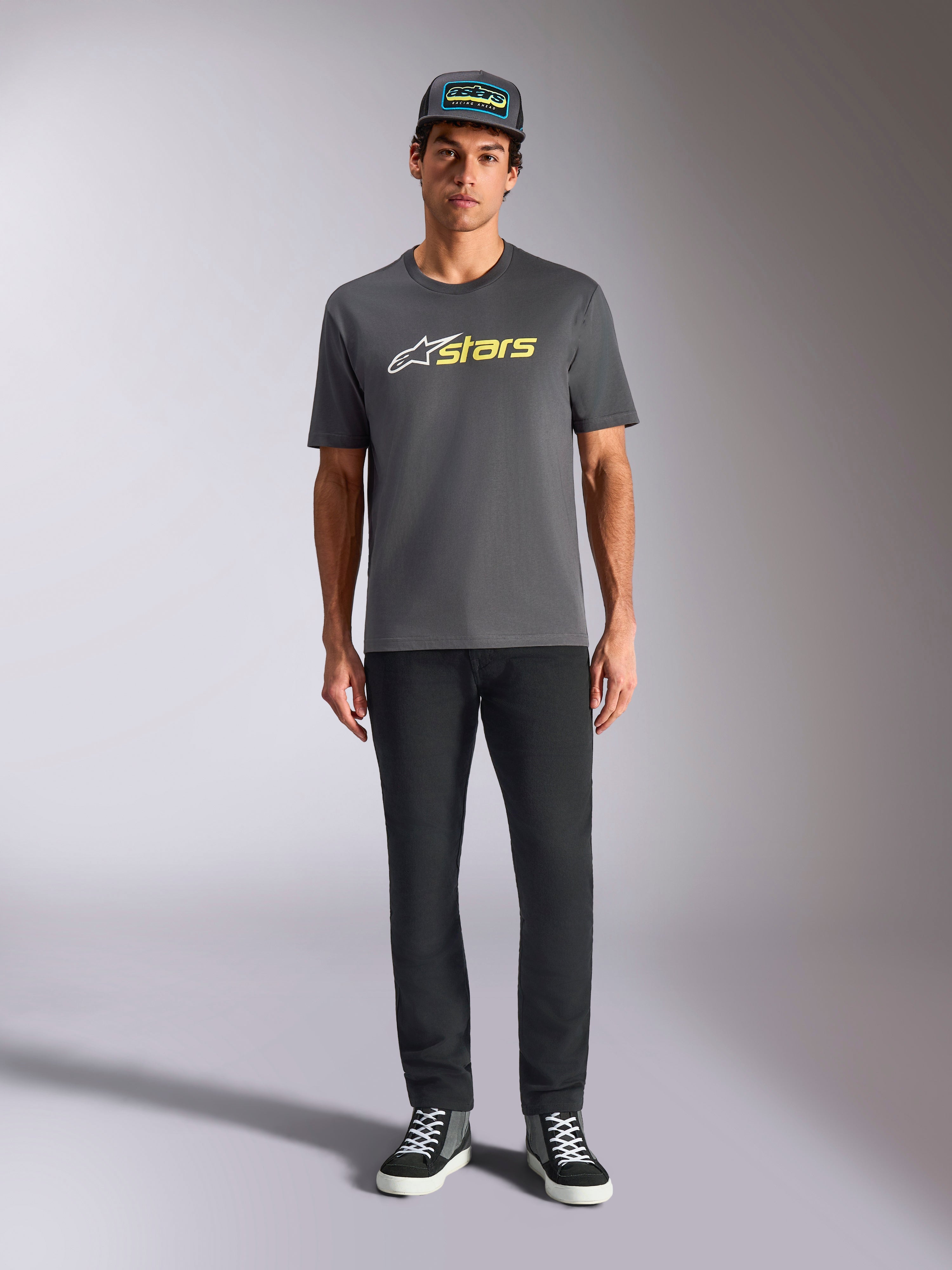 Alpinestars Blaze 2.0 CSF Tee, t-shirt de manga curta, cinzento antracite com logótipo branco e amarelo néon, usada com calças pretas e boné trucker a condizer, estilo casual de desportos motorizados