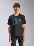 Alpinestars CSF Tee, t-shirt de manga curta, preta, grafismo de capacete de motocross azul com logótipo Astars branco, streetwear casual de inspiração motorsport, usada por modelo