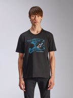 Alpinestars CSF Tee, t-shirt de manga curta, preta, grafismo de capacete de motocross azul com logótipo Astars branco, streetwear casual de inspiração motorsport, usada por modelo