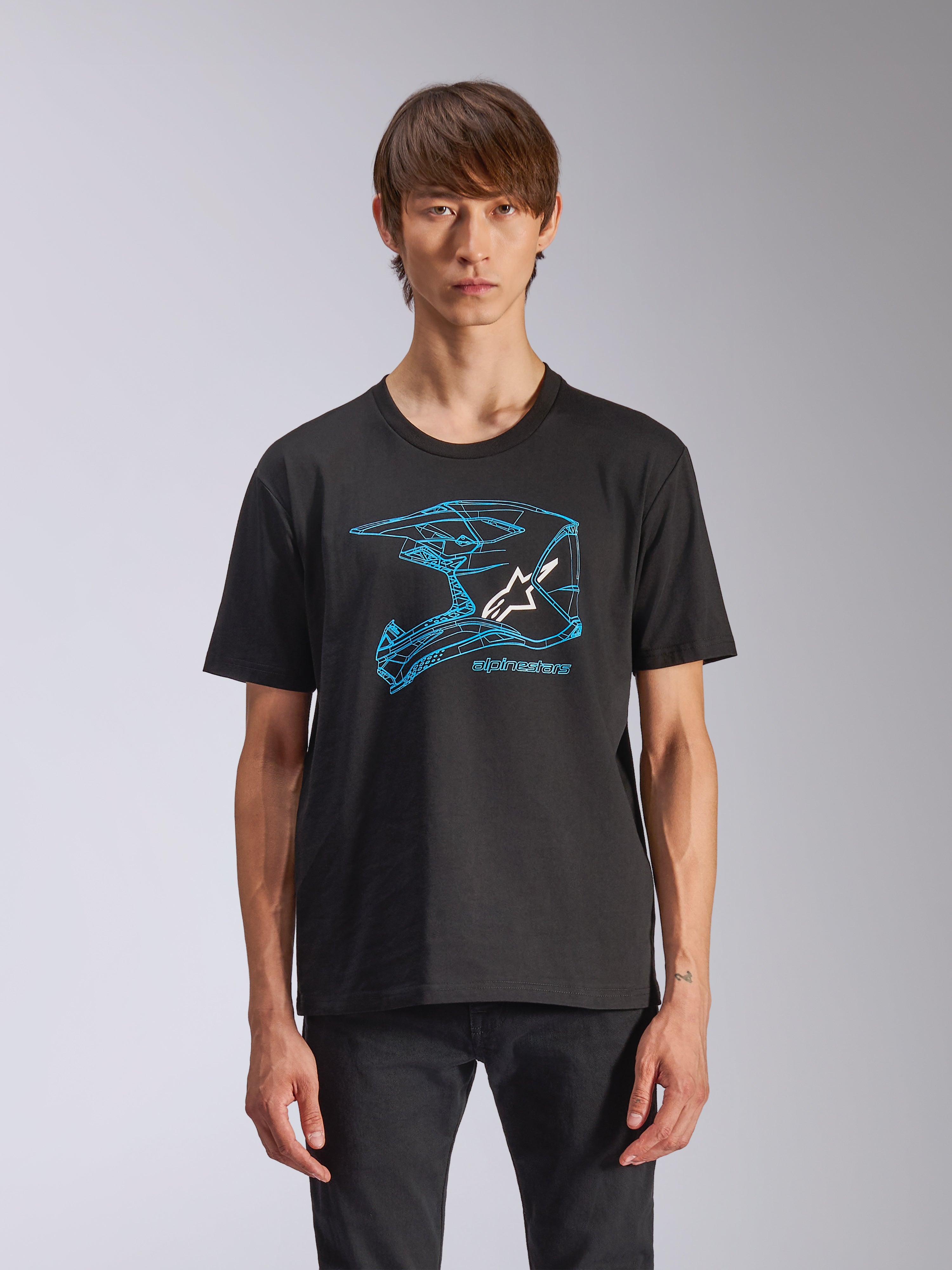 Alpinestars CSF Tee, t-shirt de manga curta, preta, grafismo de capacete de motocross azul com logótipo Astars branco, streetwear casual de inspiração motorsport, usada por modelo