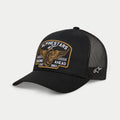 Boné Trucker Alpinestars Heritage Patch, preto, coroa estruturada com pala curva, grande patch frontal bordado com roda alada e 'Racing Ahead Est. 1963', painéis traseiros em malha preta com logótipo de estrela lateral, acessório casual de desportos motorizados