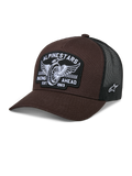 Boné Alpinestars Heritage Patch Trucker, castanho e preto, com um grande patch frontal com bordado de roda alada e o texto "RACING AHEAD EST. 1963", parte traseira em rede preta respirável, aba curva, logótipo de estrela branco lateral, acessório casual inspirado no desporto motorizado