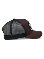 Boné Trucker Alpinestars Heritage Patch, castanho e preto, com coroa estruturada, um grande patch bordado, aba curva e parte traseira em malha preta, design casual inspirado no desporto motorizado