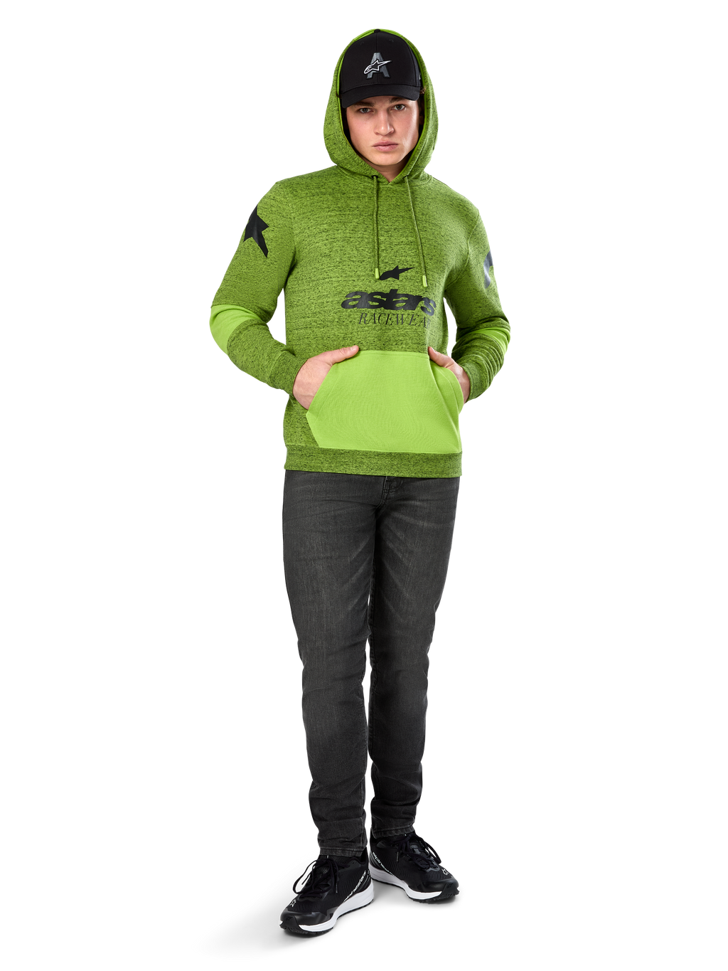 Alpinestars Hoodie Perpetuate, hoodie de lã em verde lima mesclado com bolso canguru e painéis nas mangas em verde vivo contrastante, grafismo frontal 'astars' a preto, combinado com um boné preto e calças de ganga escuras, streetwear casual inspirado no desporto motorizado