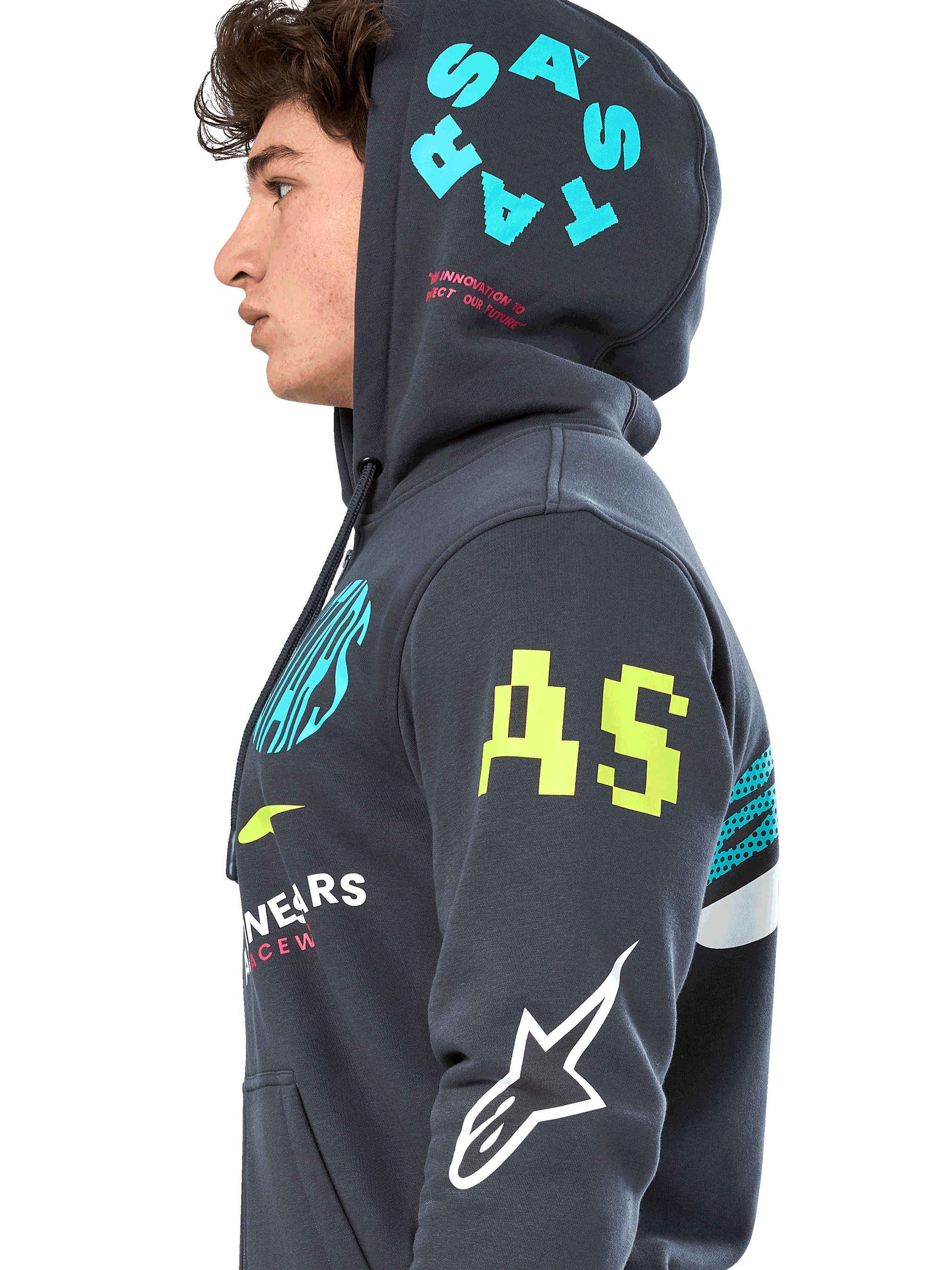Alpinestars Variegate Hoodie, Gunmetal gray zip-front fleece, side profile of model, multi-logo artwork in neon yellow, light blue, and white, features 'AS' branding on sleeve and 'STARS' on hood, casual motorsport-inspired streetwear