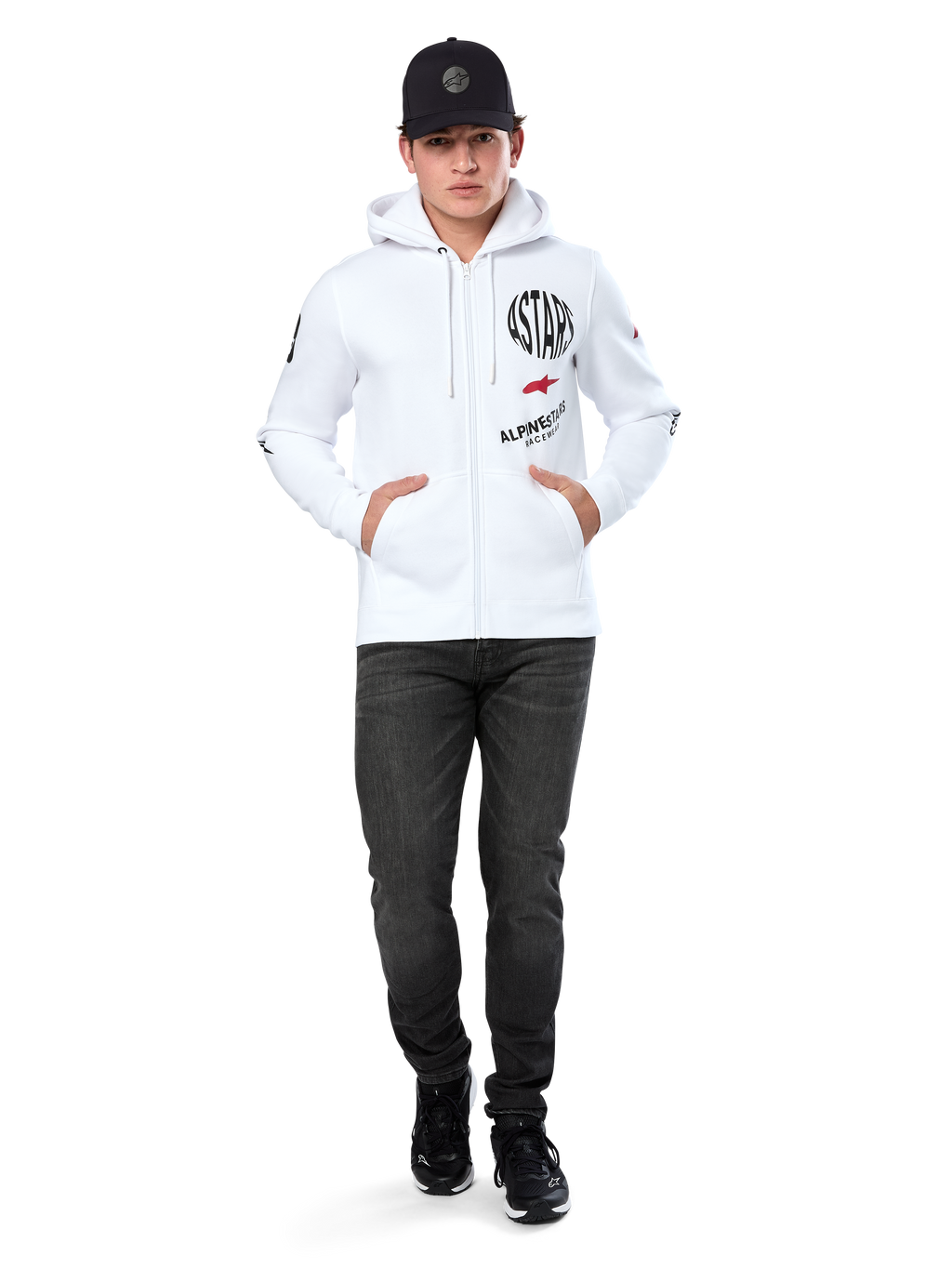 Hoodie Variegate Alpinestars, hoodie branco de lã com fecho de correr, arte com múltiplos logótipos com 'ASTARS' e logótipo de estrela vermelha no peito, detalhes gráficos nas mangas, usado por modelo com boné preto e calças de ganga pretas, streetwear casual de desportos motorizados