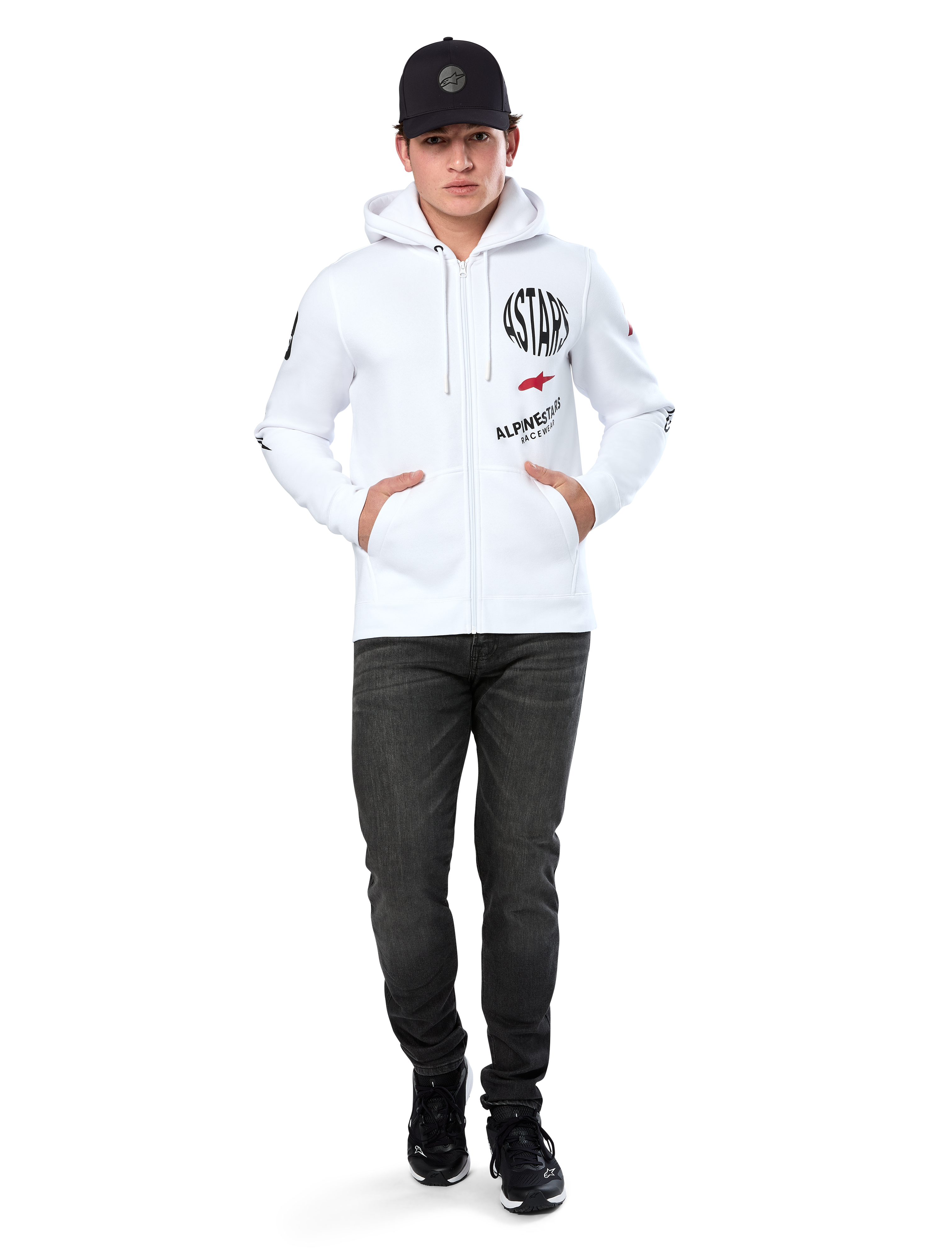 Hoodie Variegate Alpinestars, hoodie branco de lã com fecho de correr, arte com múltiplos logótipos com 'ASTARS' e logótipo de estrela vermelha no peito, detalhes gráficos nas mangas, usado por modelo com boné preto e calças de ganga pretas, streetwear casual de desportos motorizados