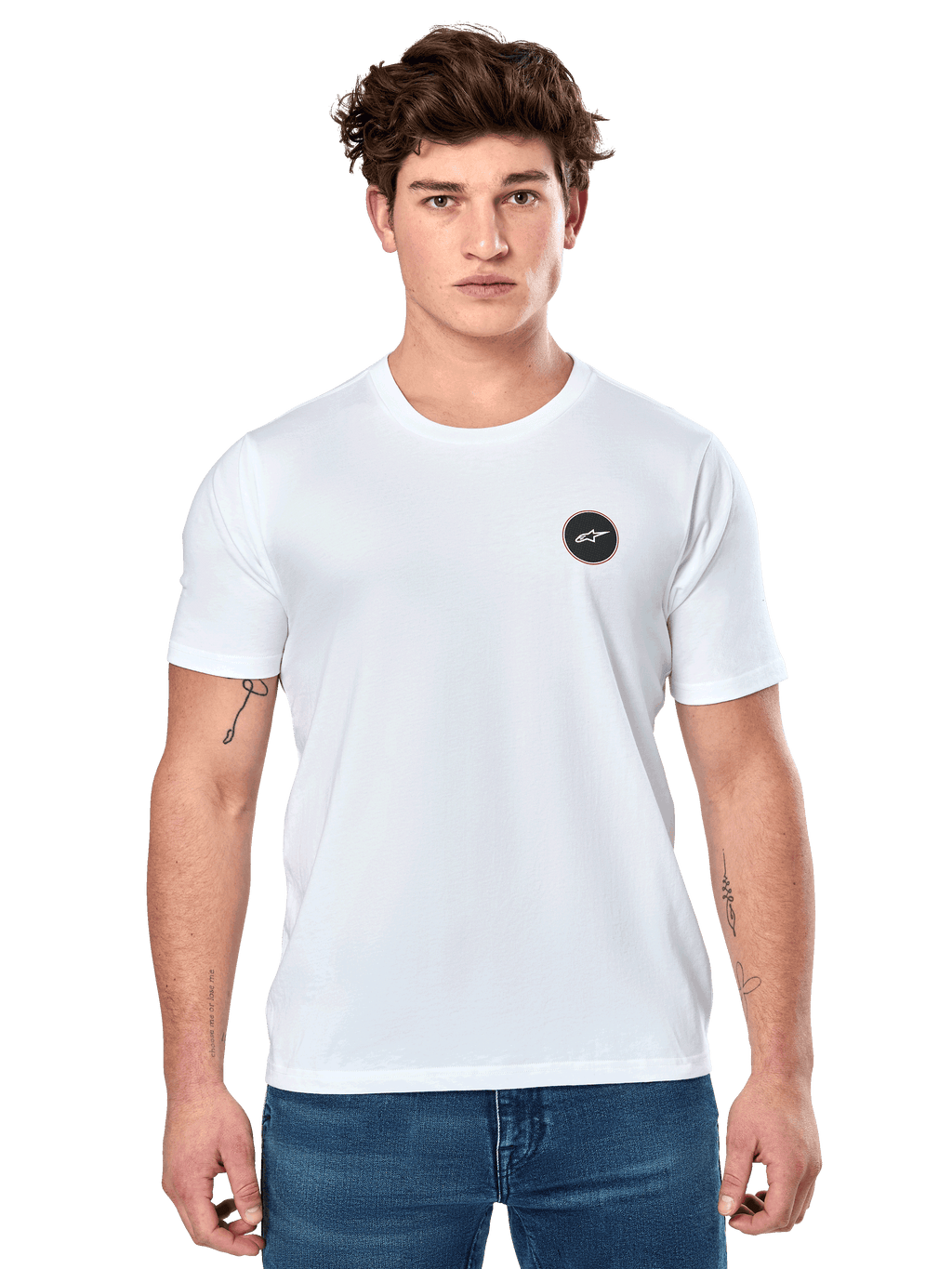 Alpinestars Dot Carbon CSF Tee, t-shirt branca de manga curta, modelo masculino com t-shirt branca, logótipo circular preto no peito e calças de ganga azuis, estilo motorsport casual