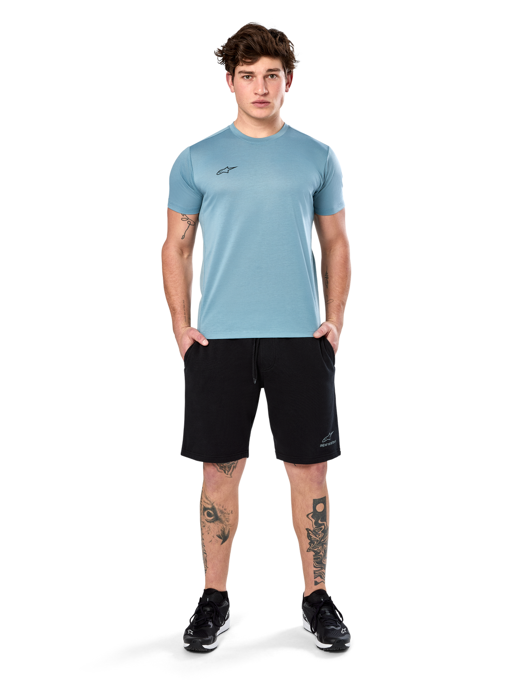Alpinestars Point Performance Tee, t-shirt de manga curta, azul gelo, com um pequeno logótipo frontal preto, gola redonda, usada por um modelo com calções pretos e sapatilhas pretas, roupa desportiva casual com absorção de humidade