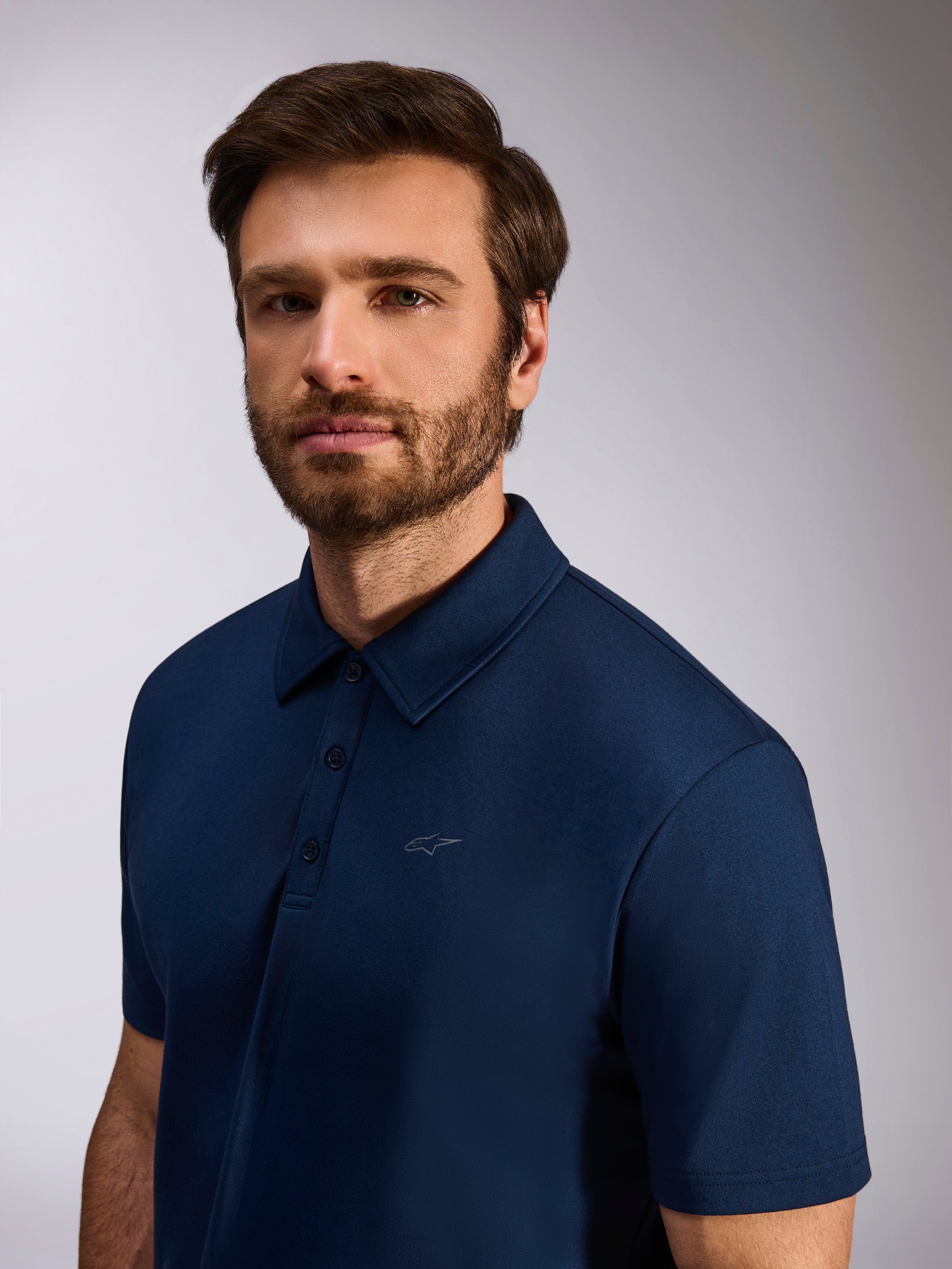 Modelo a vestir Polo Alpinestars Impetus Sport, azul-marinho, polo de manga curta em malha, com carcela de três botões e logótipo Astars discreto no peito, vestuário casual de lifestyle de desportos motorizados