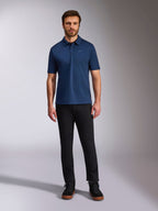 Alpinestars Impetus Sport Polo, polo de manga curta, azul-marinho, pequeno logótipo Astars prateado no peito, carcela de três botões, usado por modelo com calças e botas pretas, vestuário desportivo casual inspirado no desporto motorizado