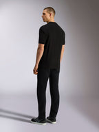 Alpinestars Endeavor Classic Polo, polo de manga curta em piqué, preto, vista traseira de modelo masculino a usar calças pretas e sapatilhas, streetwear casual inspirado no desporto motorizado